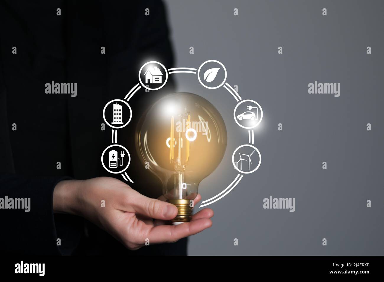 Woman hand holding light bulb with icons energy sources for renewable ...