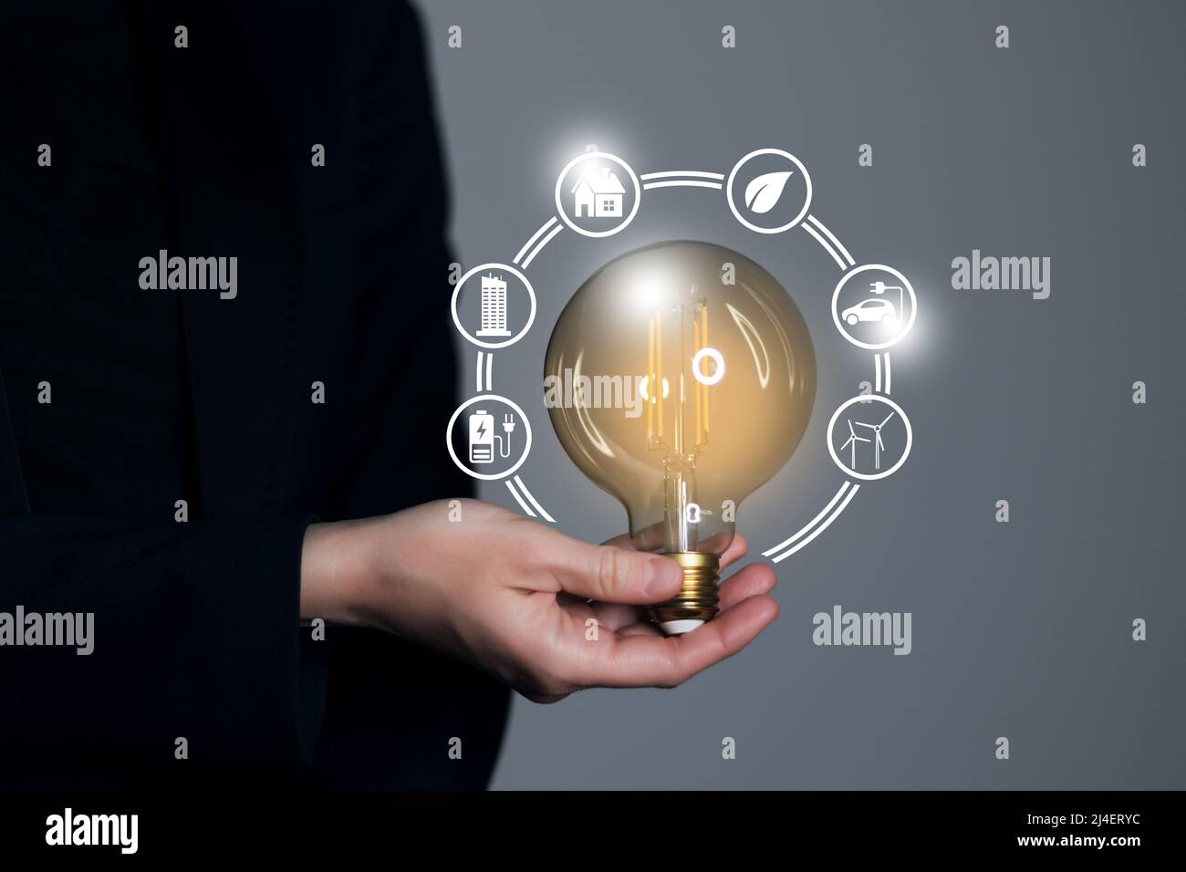 Woman hand holding light bulb with icons energy sources for renewable ...
