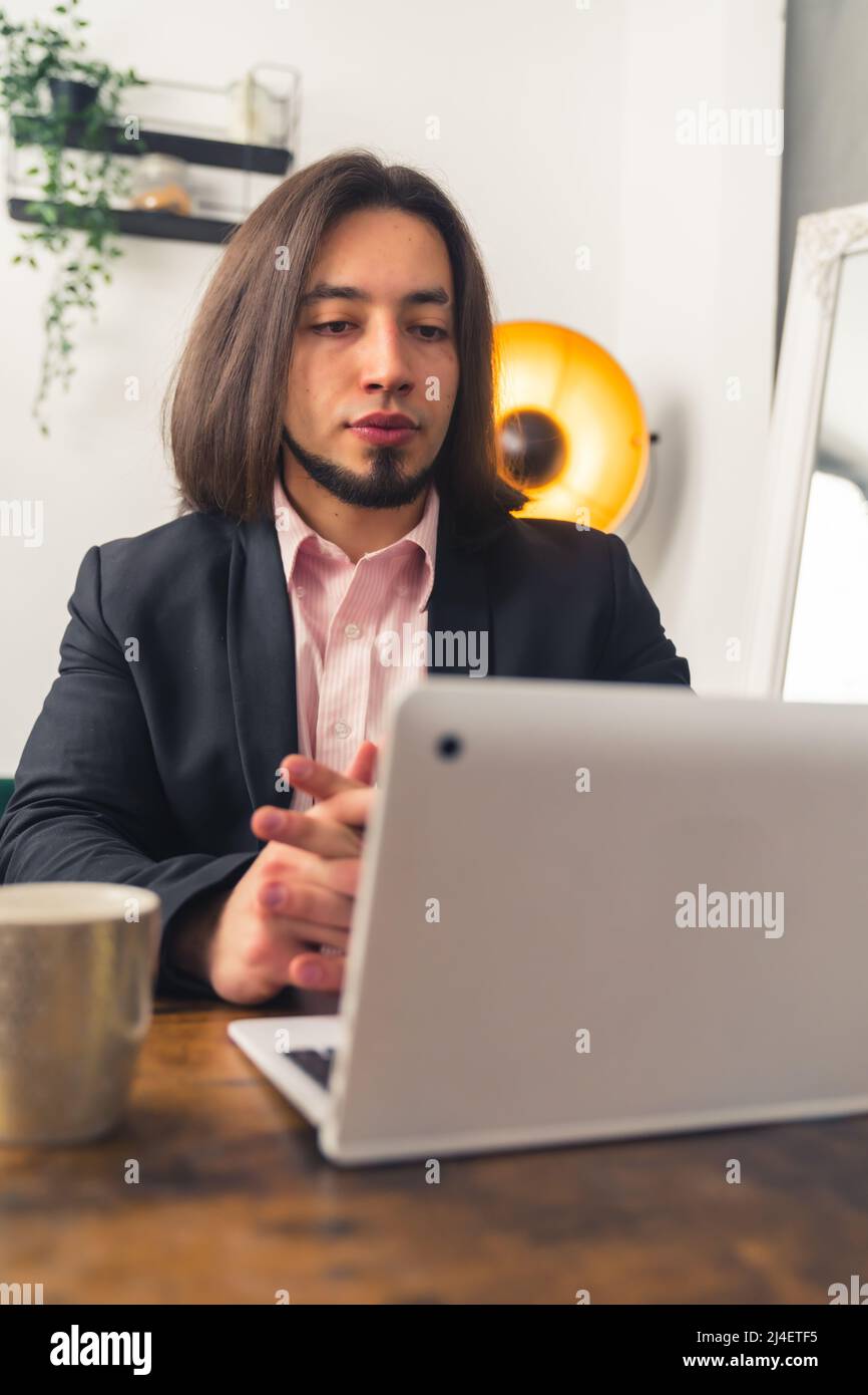 Handsome young man in a suit having an online meeting, remote job concept home background . High quality photo Stock Photo