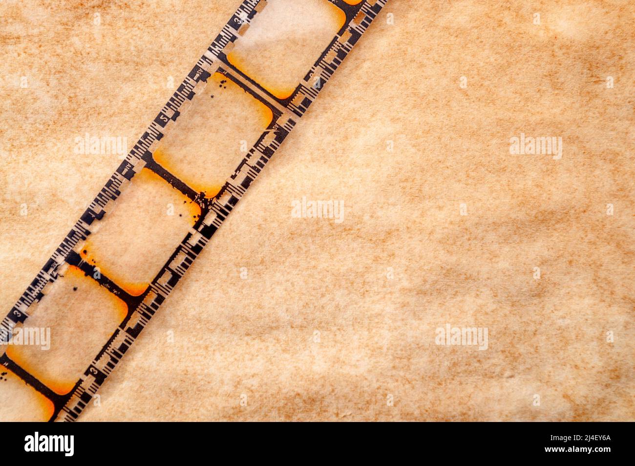 Video recording, nostalgic movie and vintage cinematography concept theme with close up on retro film reel strip isolated on grungy brown background w Stock Photo
