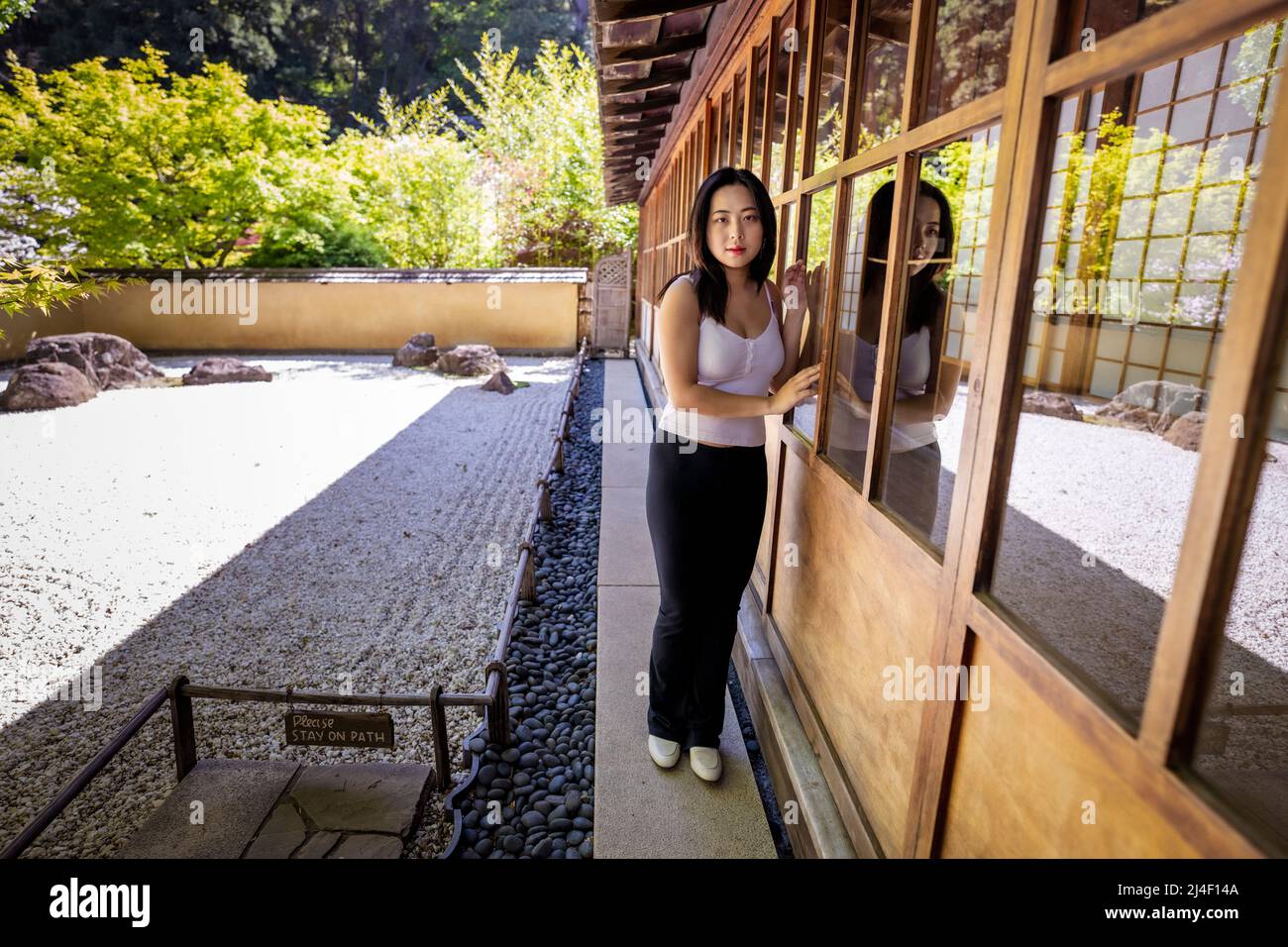 Young Chinese Woman Standing beside a Japanese Rock Garden Stock Photo