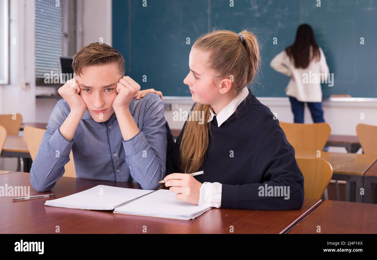 Girl student supporting upset friend in classroom Stock Photo Alamy