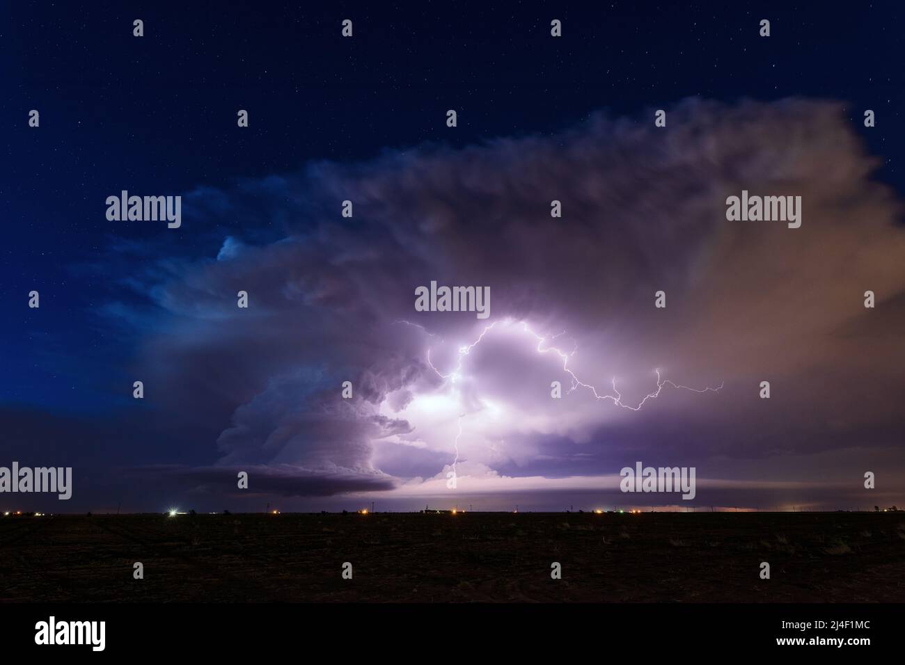 Lightning illuminates a supercell thunderstorm cloud in the night sky near Littlefield, Texas Stock Photo