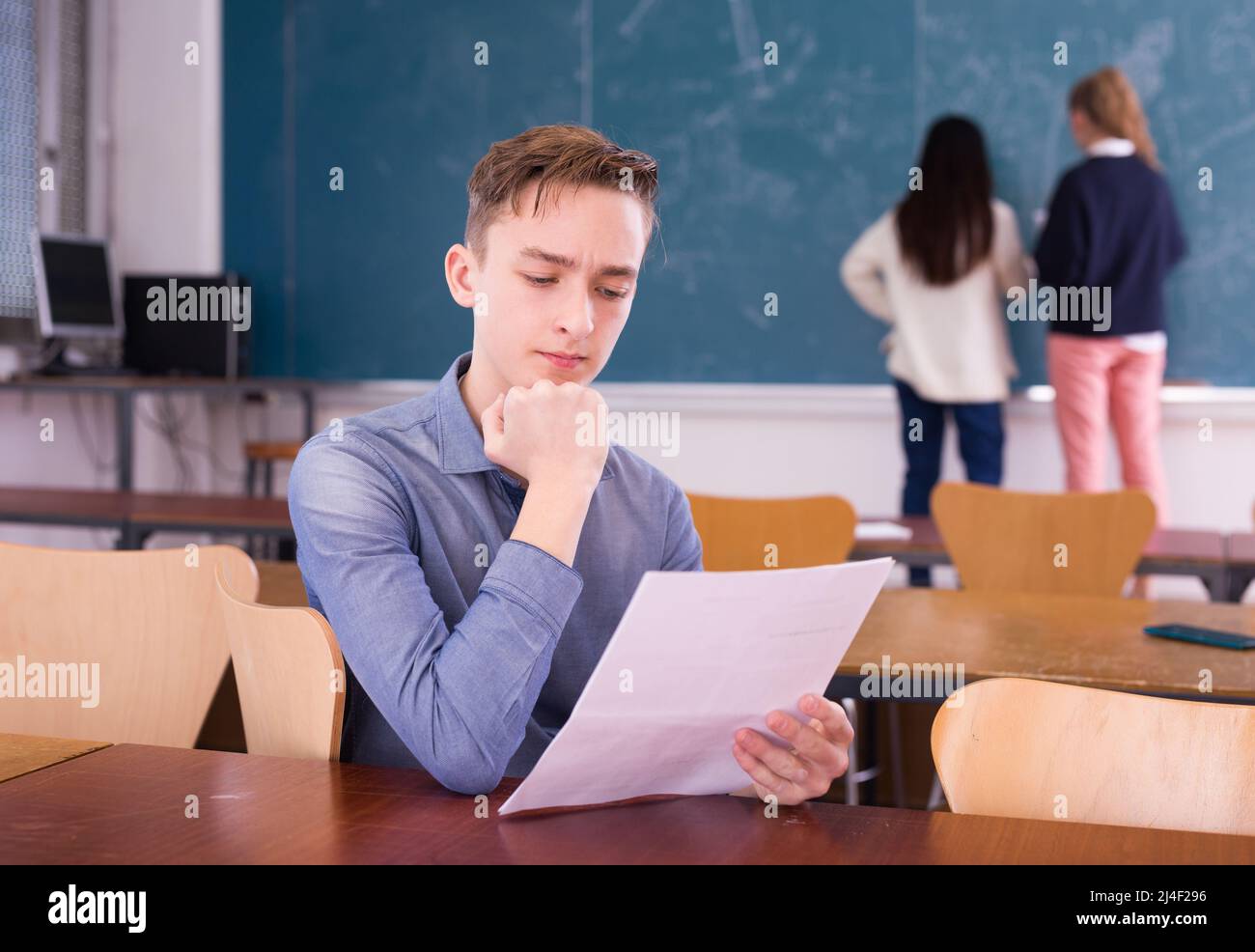 Young thoughtful guy preparing for the exam in classroom Stock Photo