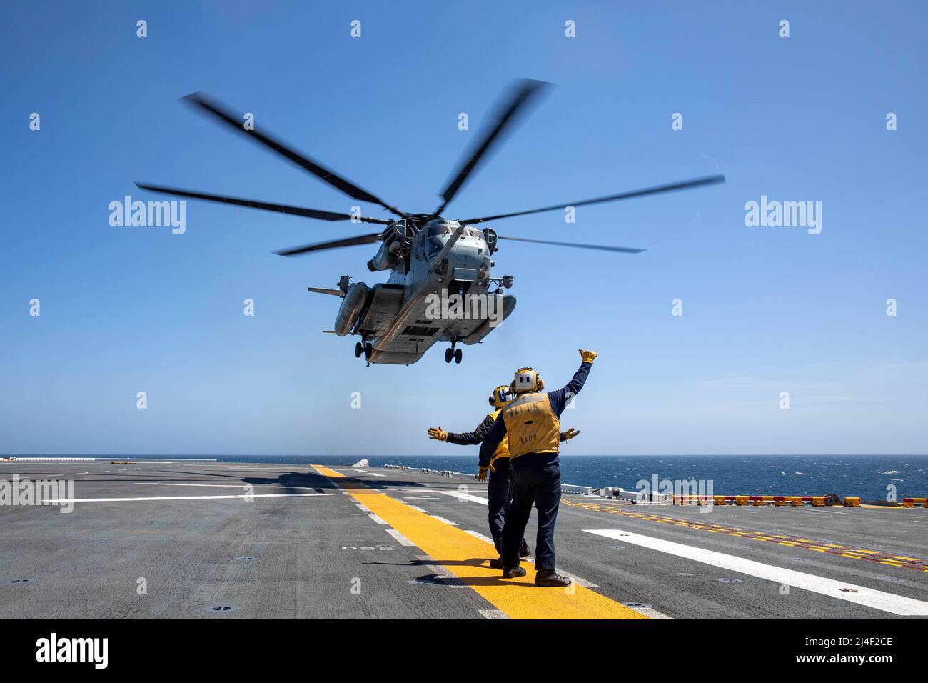 220413-N-NY430-2098    PACIFIC OCEAN (April 13, 2022) – Aviation Boatswain’s Mate (Handling) 3rd Class Jonathan Walker, right, and Airman Kory Vogel direct a CH-53E Super Stallion, assigned to Marine Heavy Helicopter Squadron (HMH) 462, as it takes-off from the flight deck of Amphibious Assault Ship USS Makin Island (LHD 8), April 13. Aviation Boatswain’s Mates direct the movement and spotting of aircraft ashore and afloat. Makin Island is underway conducting routine operations in U.S. 3rd Fleet. (U.S. Navy photo by Mass Communication Specialist 2nd Class Kristopher S. Haley) Stock Photo