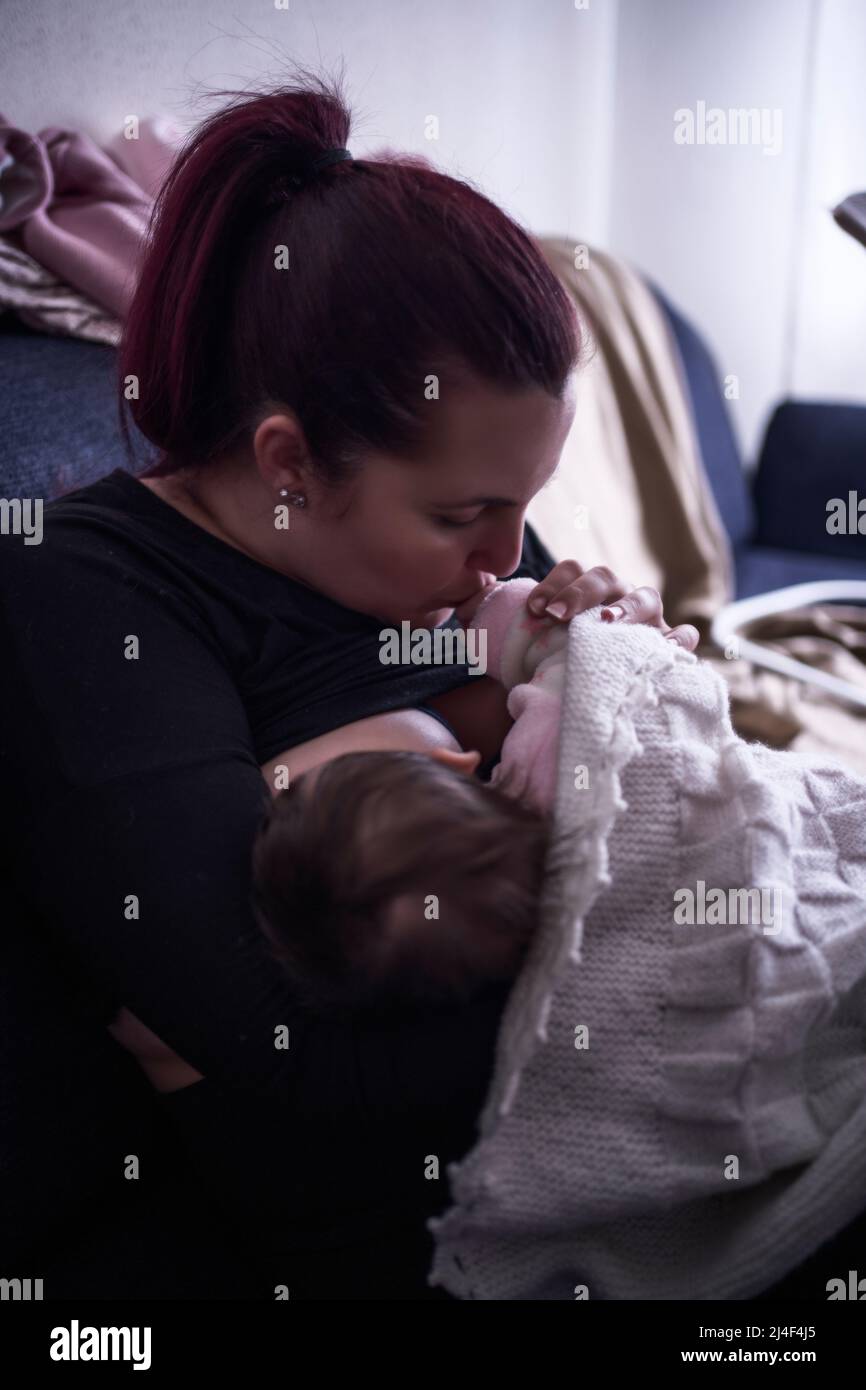 A young mother is breastfeeding her baby Stock Photo