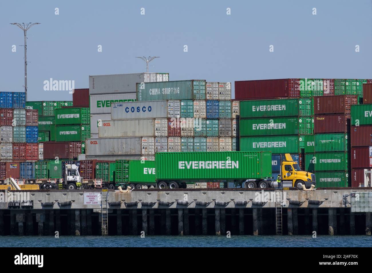 Stacked shipping containers and semi truck shown at  the Port of Los Angeles, California, USA, on April 1,2 2022. Stock Photo