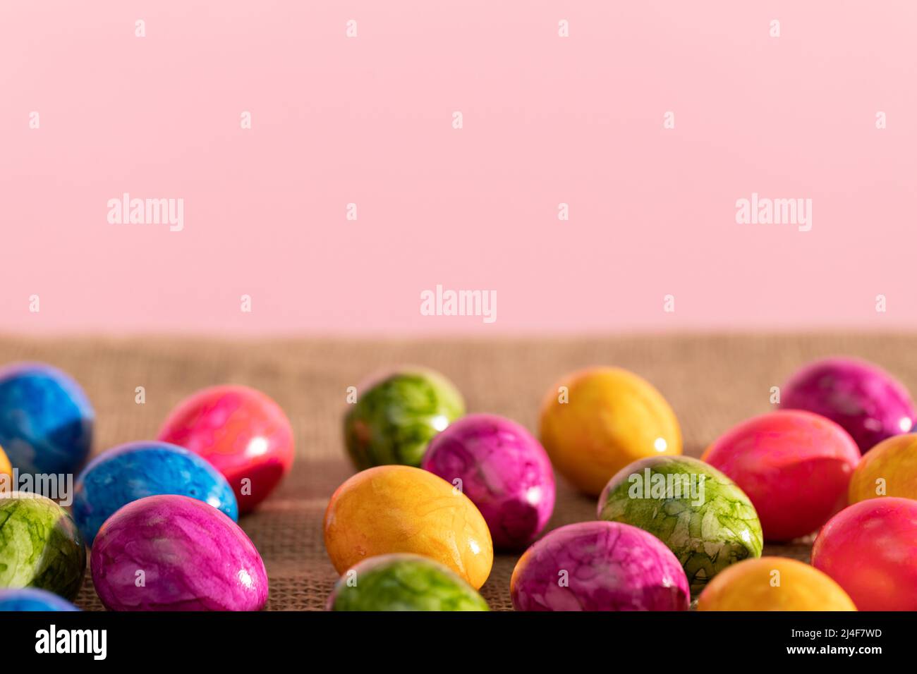Scattered colored chicken eggs on linen fabric. Easter. Stock Photo