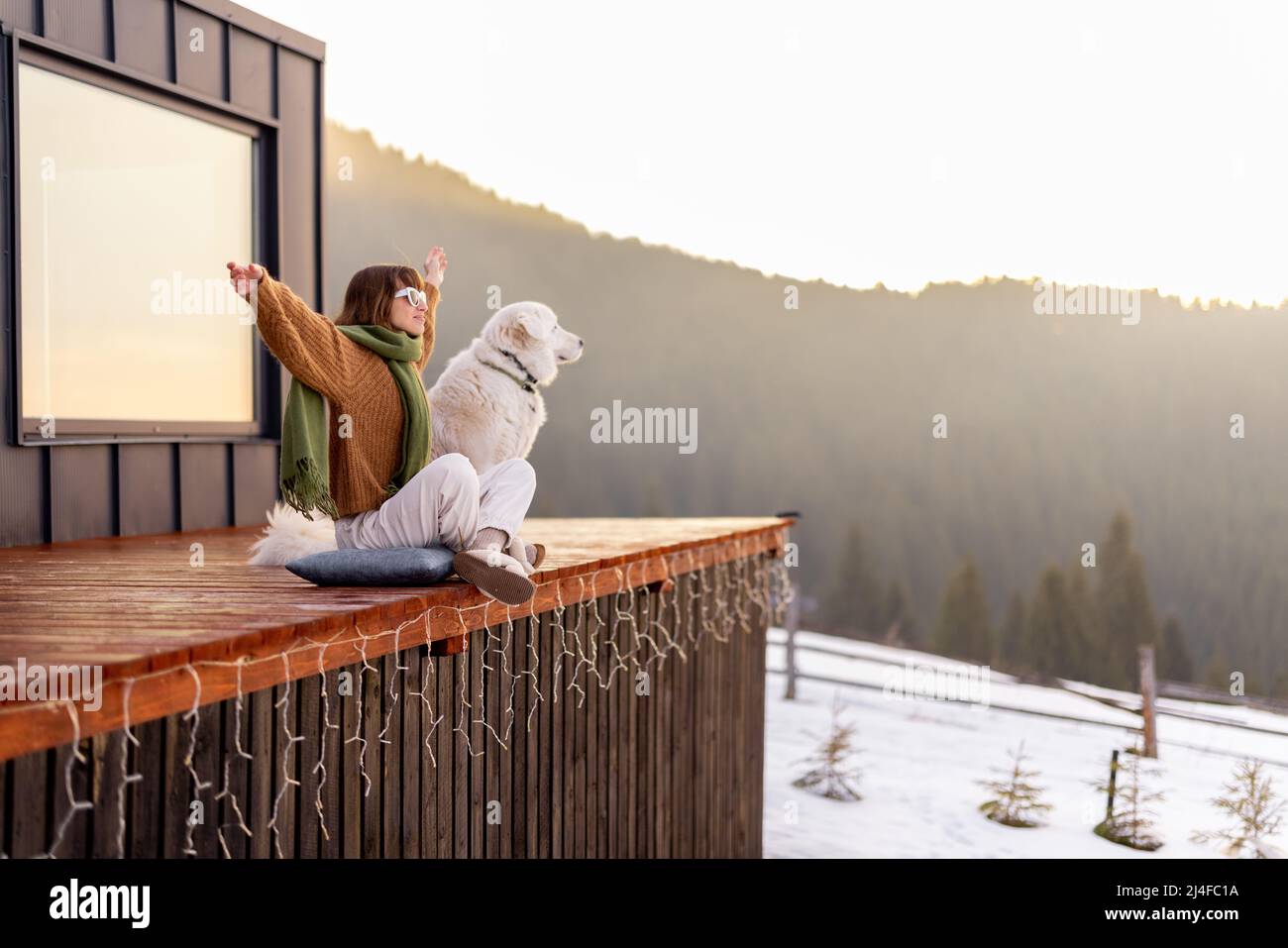 Woman with her dog resting on terrace of tiny house on nature Stock ...