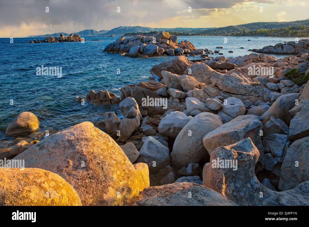 View of the rocky coastline and the blue Mediterranean sea at the sunset, Tamaricciu beach, Corse du Sud, Corsica, France Stock Photo