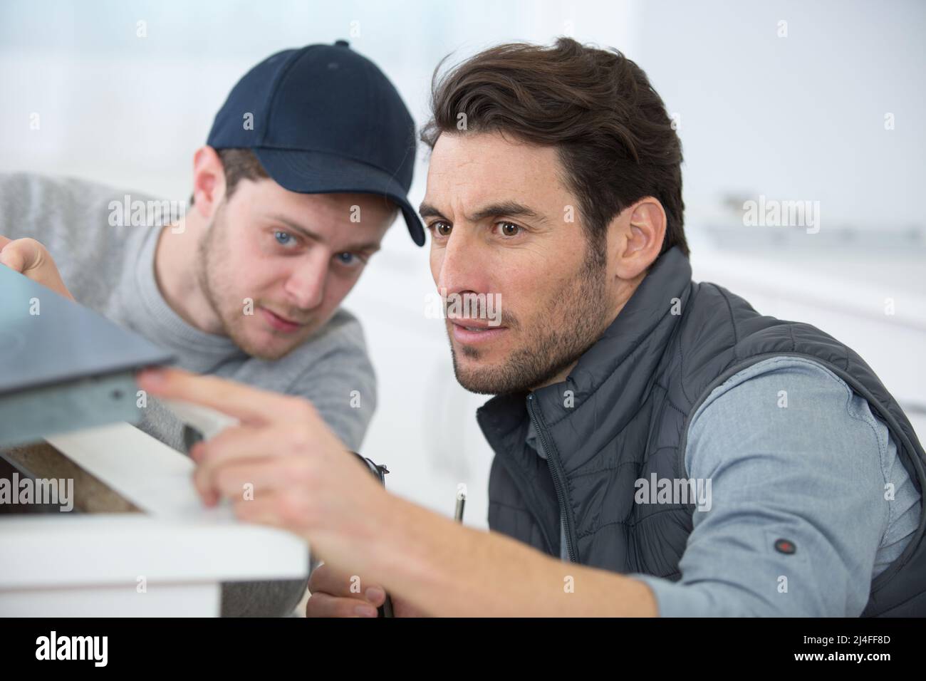 two men installing a new kitchen hob Stock Photo Alamy