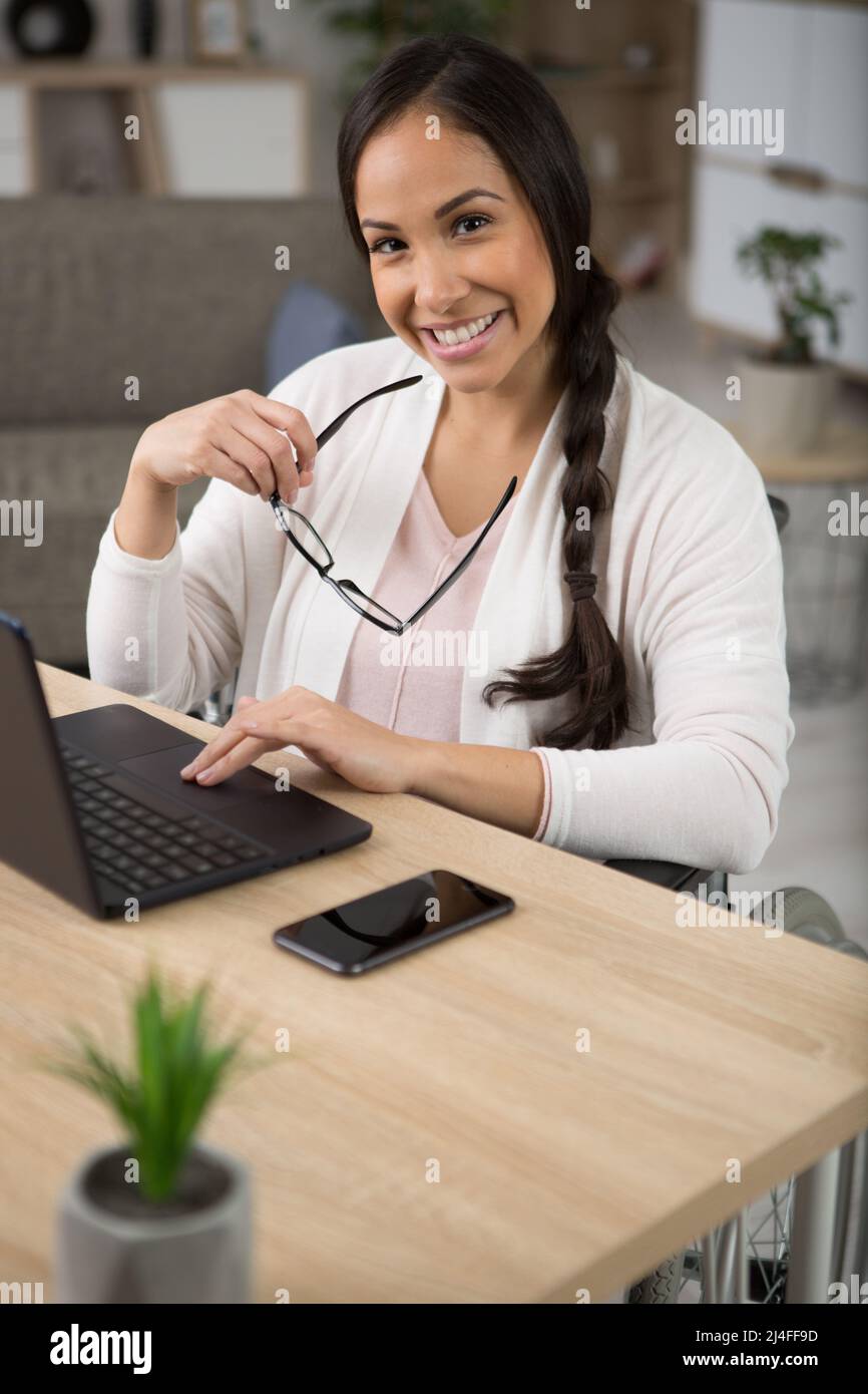 woman in a wheelchair using notebook computer in the home Stock Photo ...