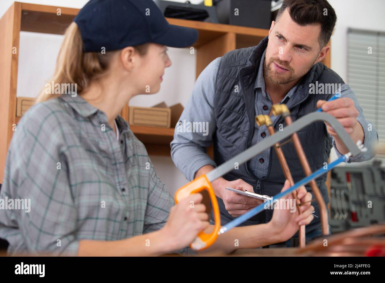 tradeswoman cutting copper pipe with hacksaw Stock Photo Alamy