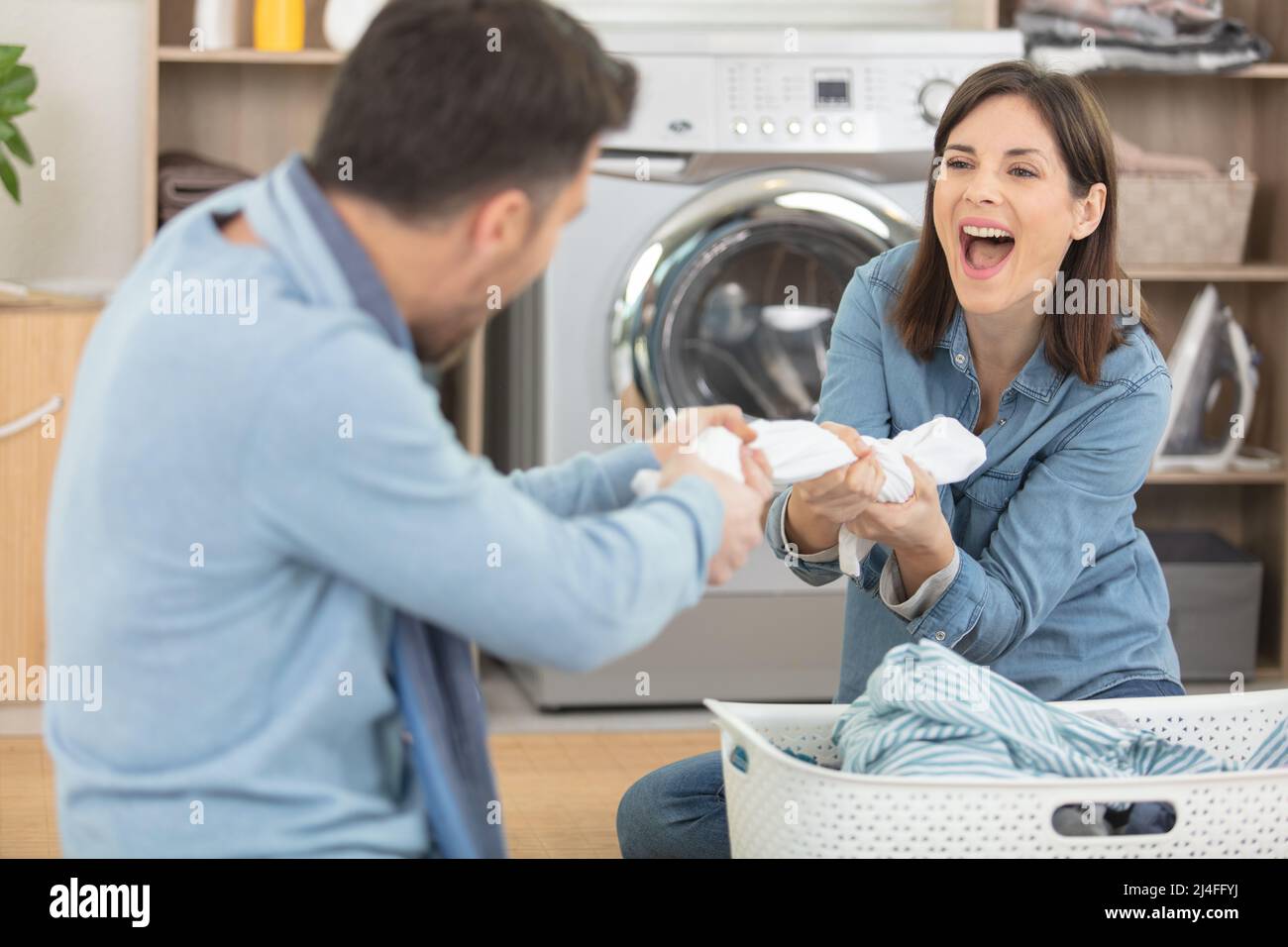 young couple having fun while doing laundry Stock Photo - Alamy