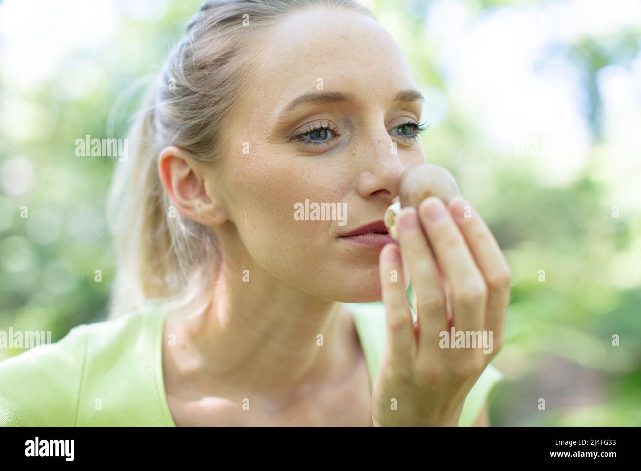 woman smelling a wild mushroom Stock Photo