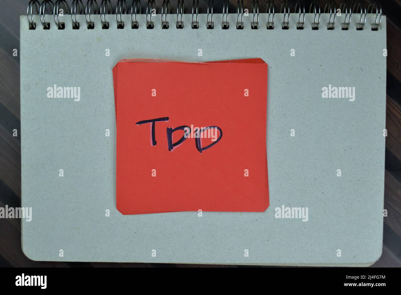 TDD write on sticky notes isolated on Wooden Table. Stock Photo