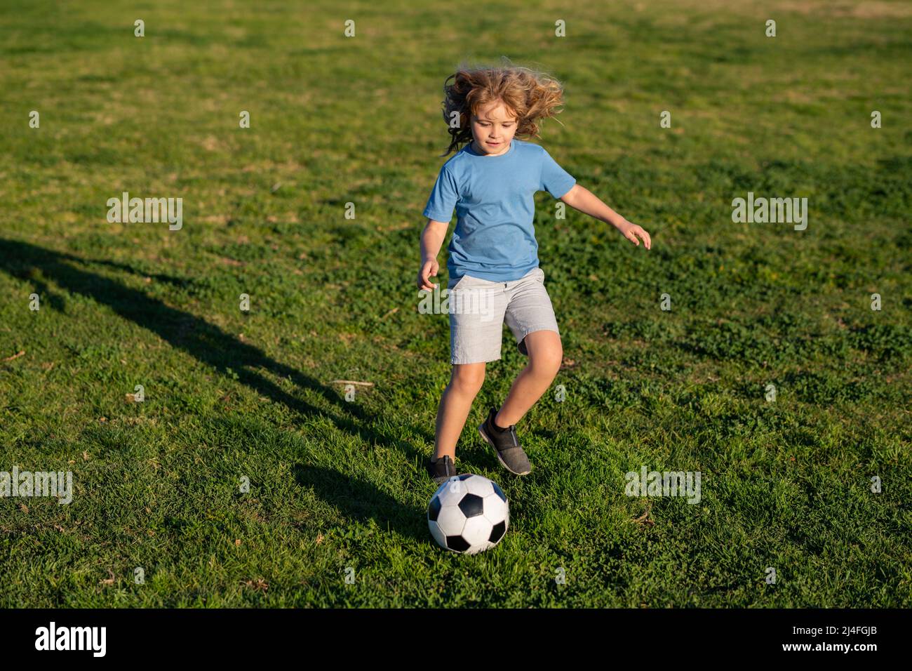 Kid playing soccer, happy child enjoying sports football game, kids