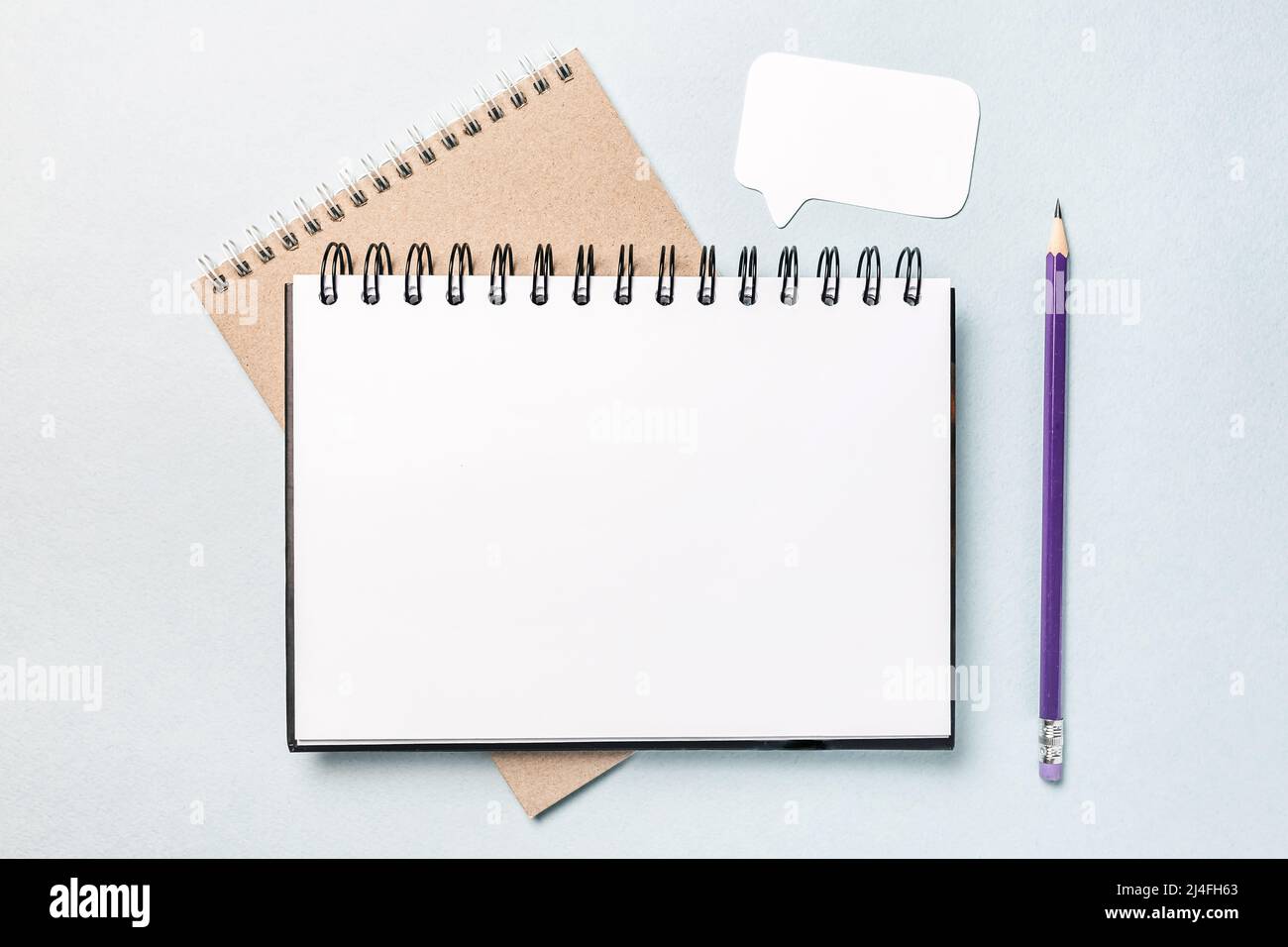 Notepad, white sticker and pensil on the desk. Mock up in copy space ...