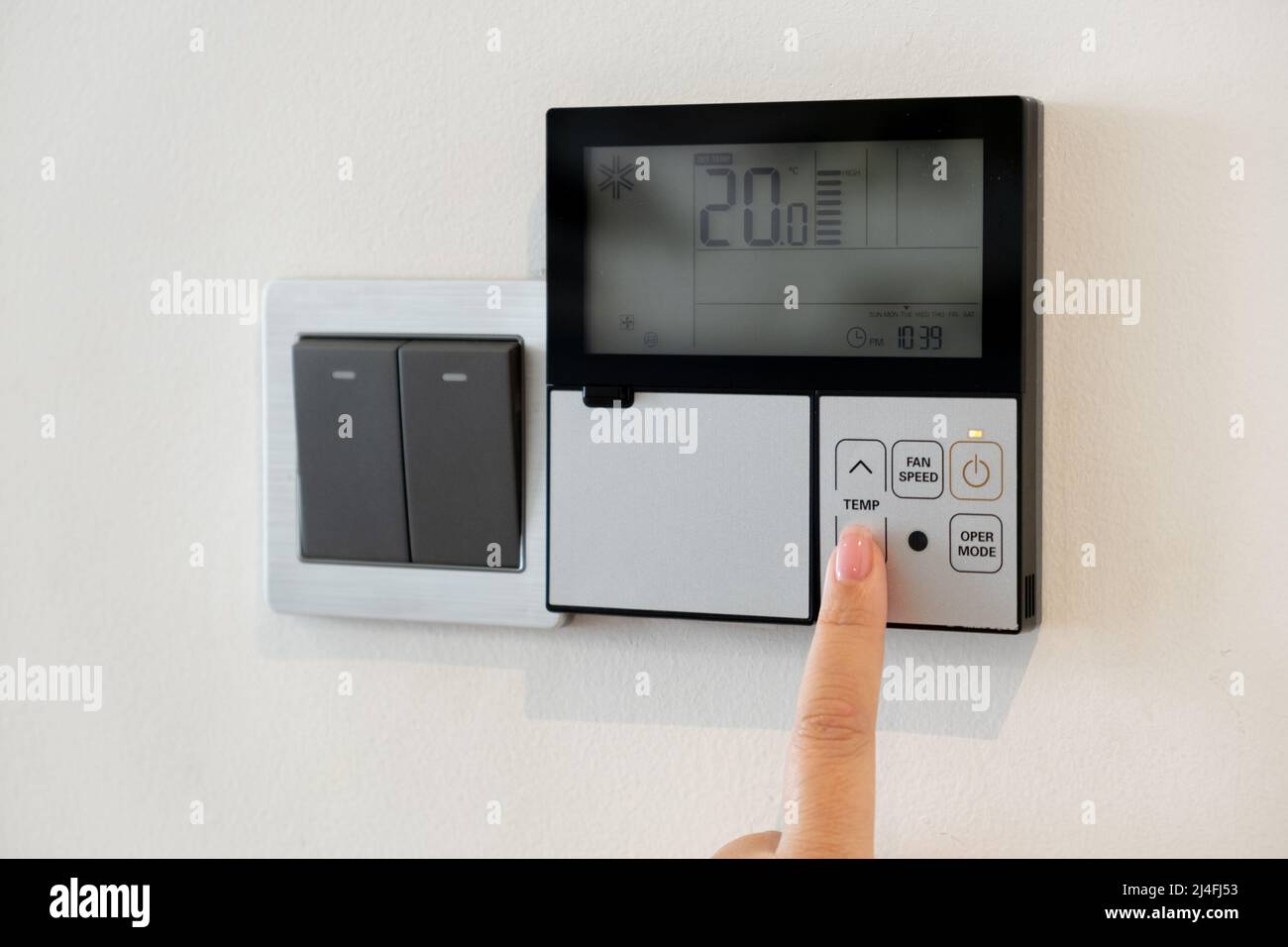 The air conditioning and heating control panel for the apartment and office is located on a white wall Stock Photo