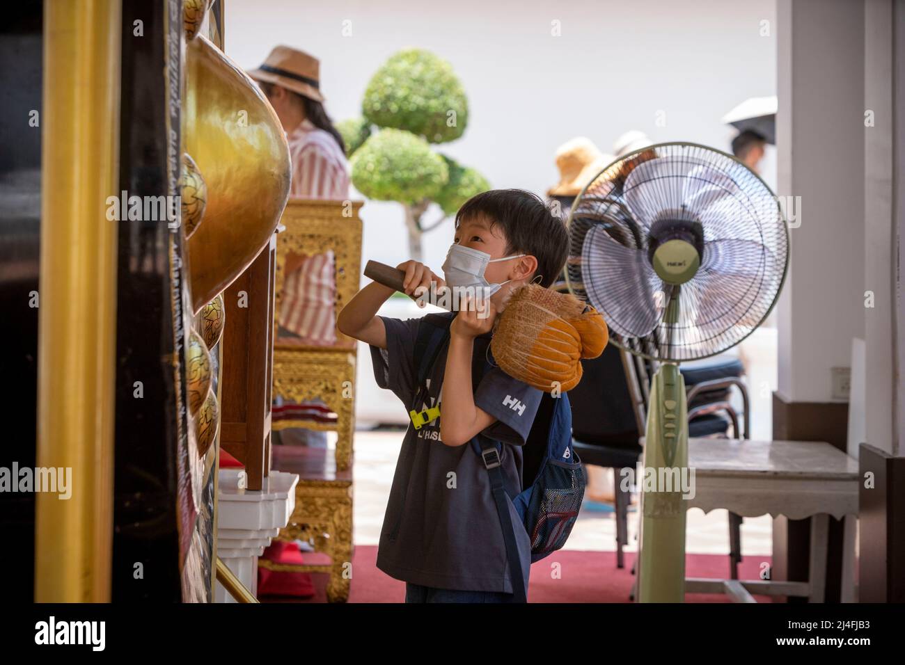 Bangkok, Bangkok, Thailand. 15th Apr, 2022. A little boy hits a giant gong at Bangkok's Wat Pho temple. Thailand's traditional new year celebration based on the lunar calendar, Songkran, also known as the water festival, usually takes place every year during April or May. Temples throughout the country put on special festivities and traditional activities for the multi day event, which falls on April 13-15 in 2022. (Credit Image: © Adryel Talamantes/ZUMA Press Wire) Stock Photo