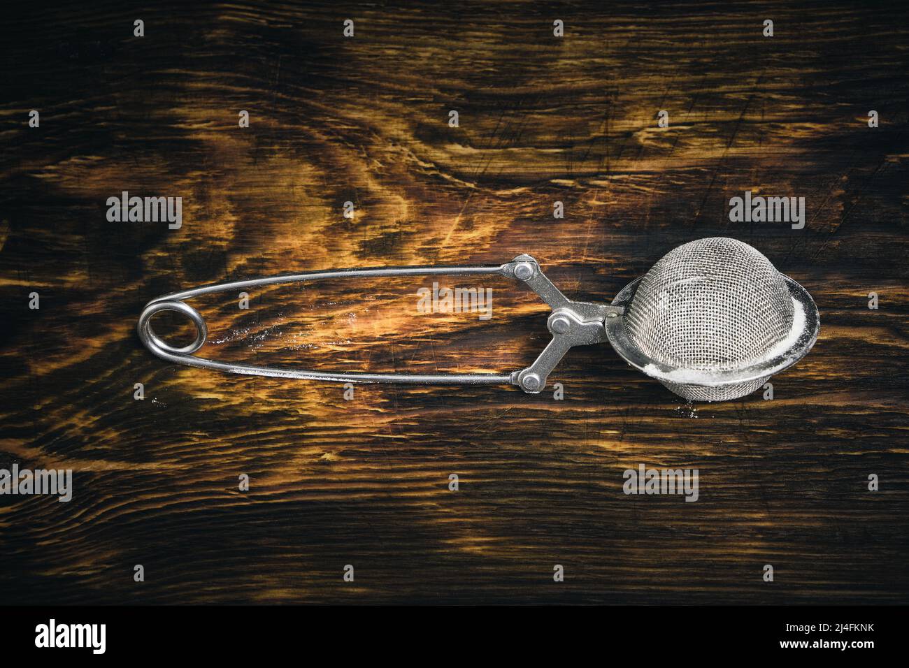 Metal sieve on a wooden background for sifting flour, powdered sugar