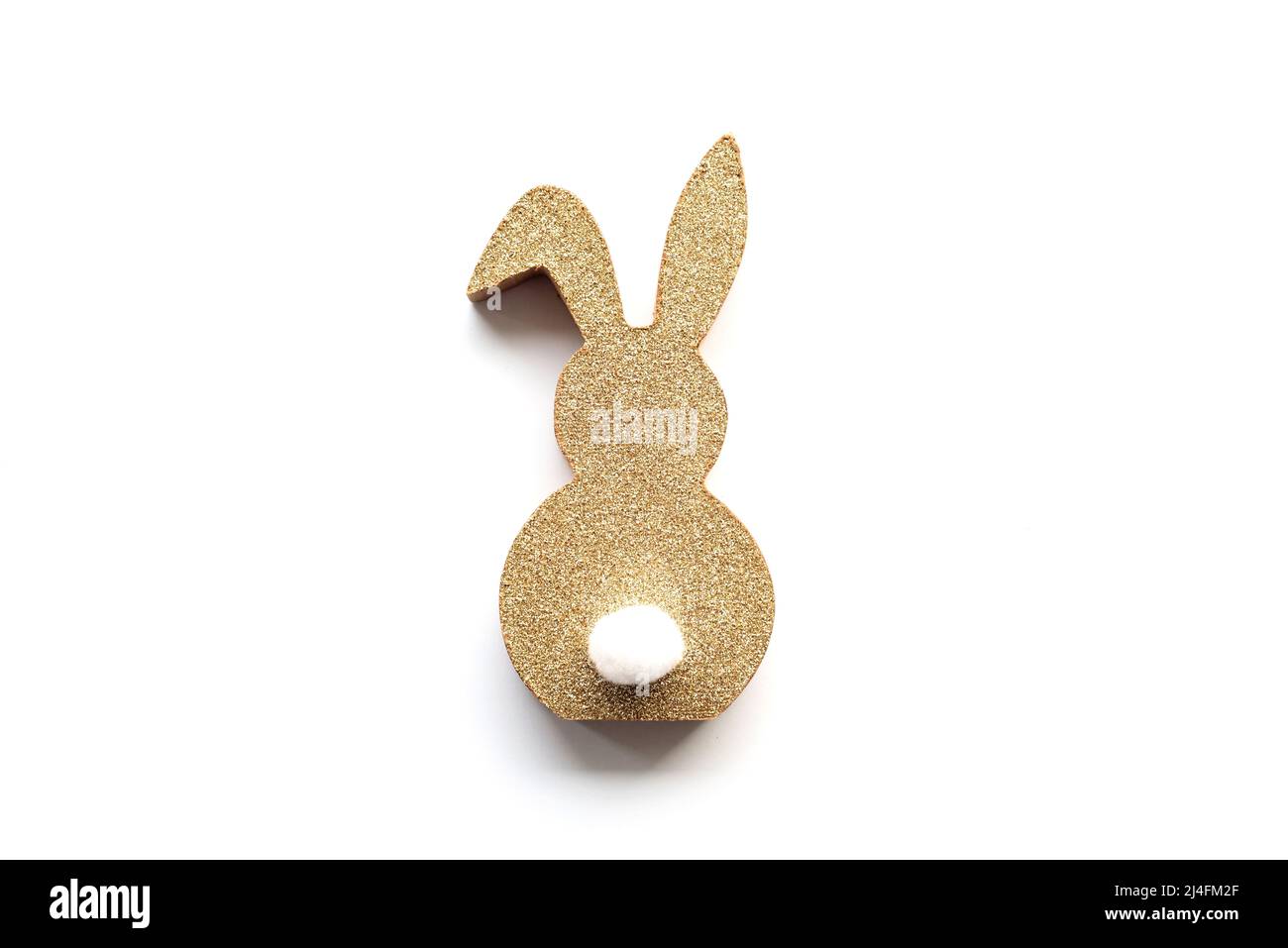 Cute Easter golden bunny on a white background. Happy Easter minimal concept. Copy space, soft selective focus. Stock Photo