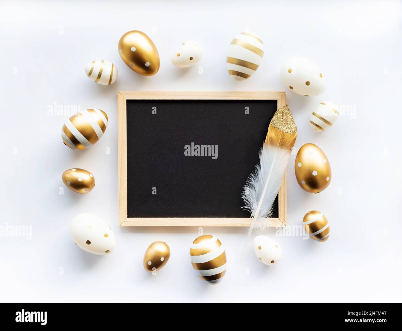 Gold white eggs and feather on a white background. Minimal concept ...