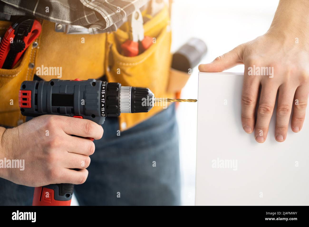 Worker drilling board using mobile drill Stock Photo Alamy