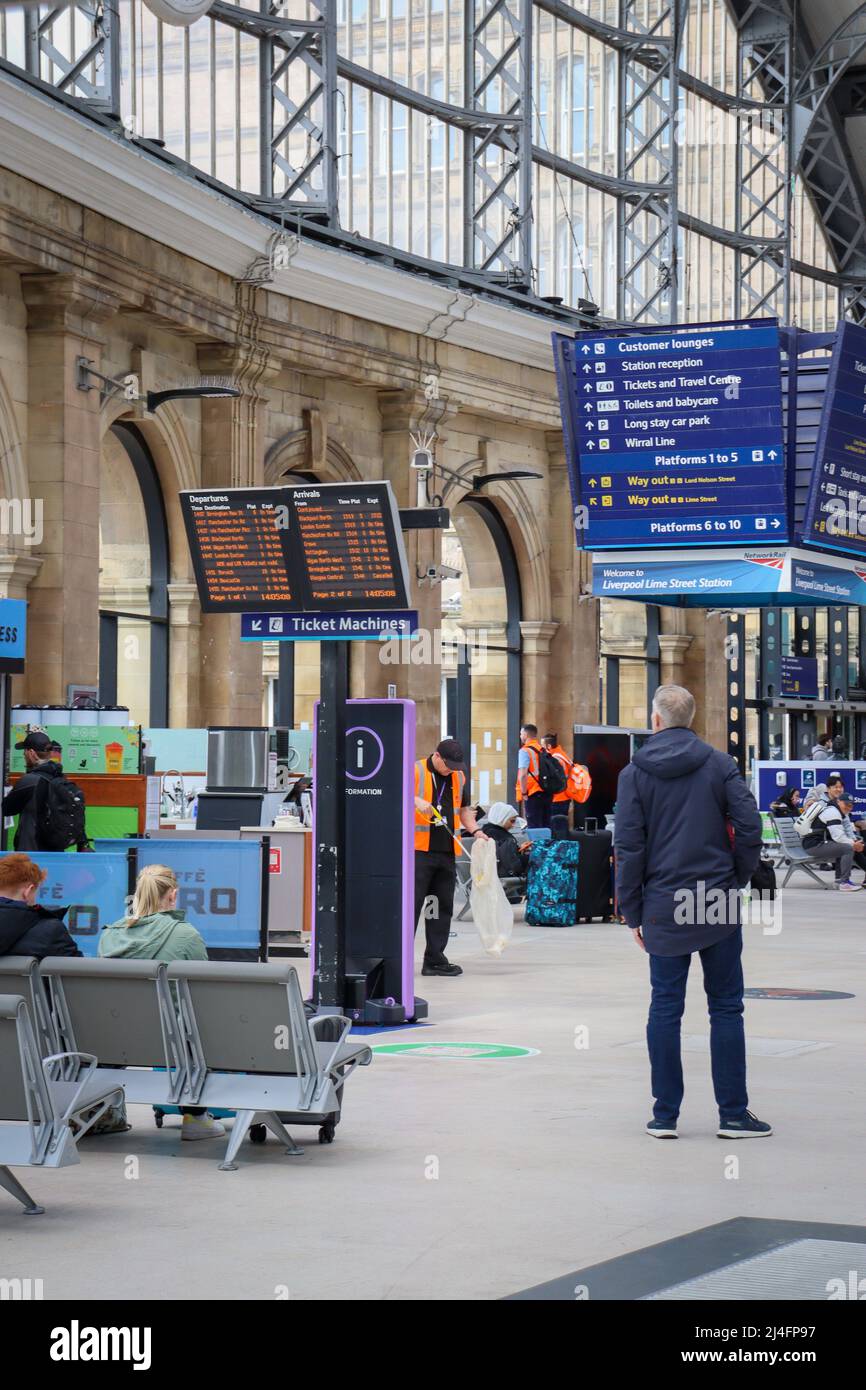 Man / Passenger observing the arrivals / departure boards at Lime Steet Train Station, Liverpool Stock Photo