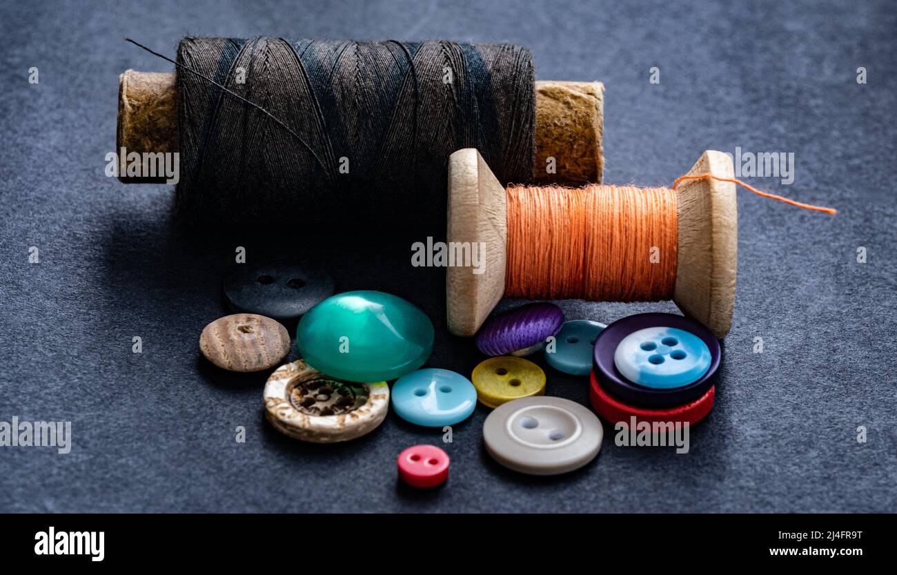 Colorful sewing buttons and thread spools macro Stock Photo