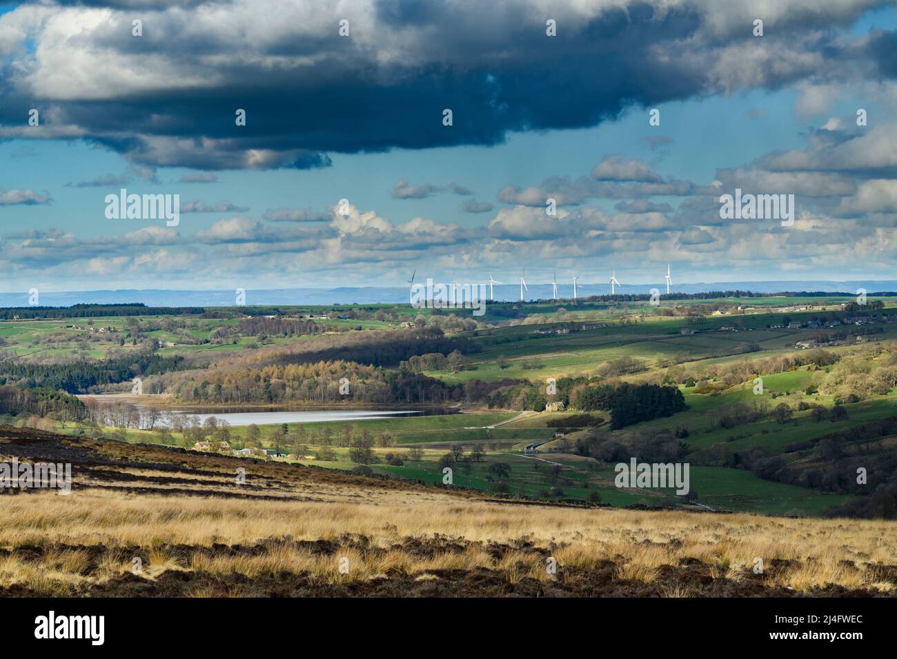 Scenic sunny rural Washburn Valley (Swinsty reservoir, farmland pastures, tall high giant wind turbine towers, cloudy) - North Yorkshire, England UK. Stock Photo