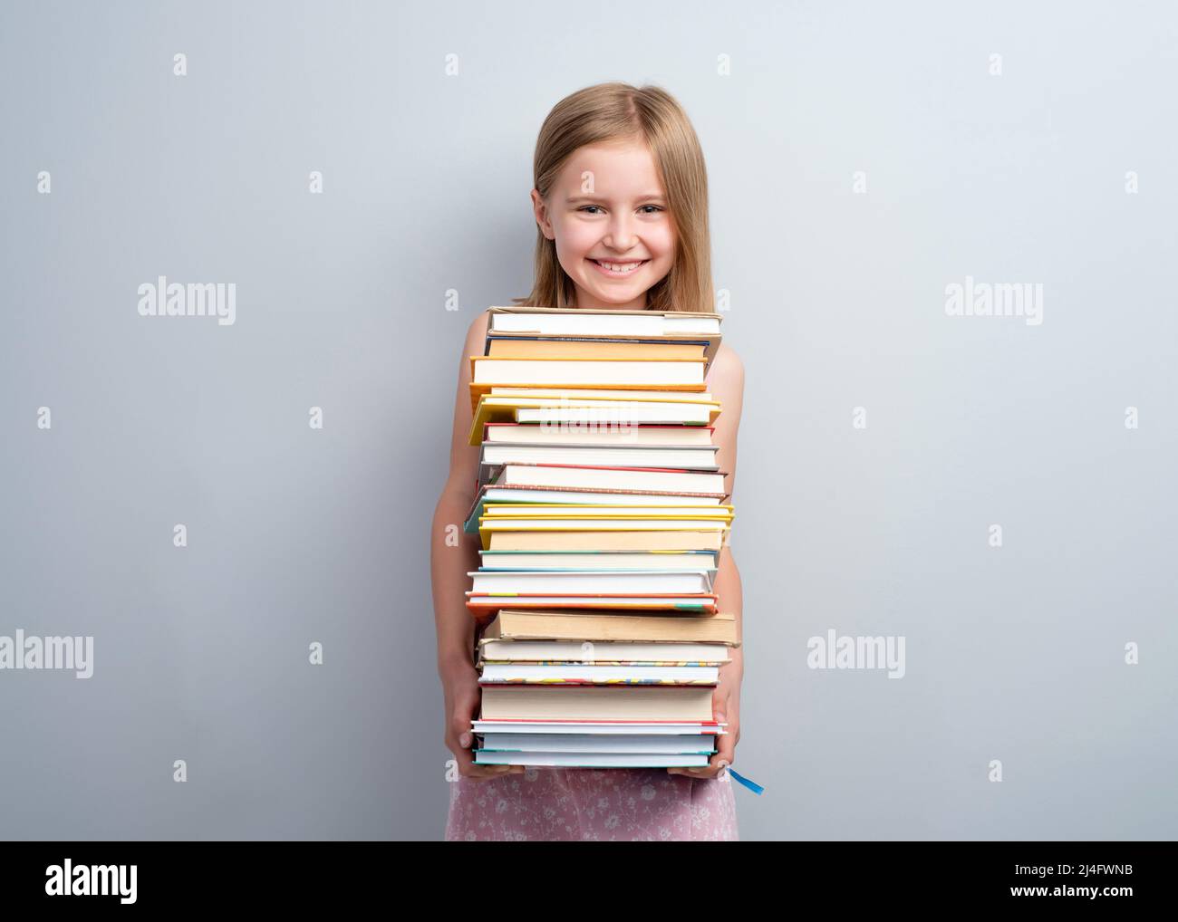 School girl holding stack of books Stock Photo - Alamy