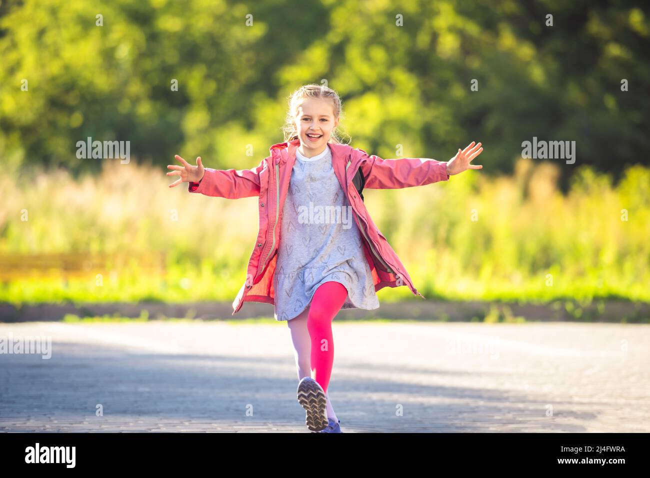 Happy little girl running after school Stock Photo Alamy
