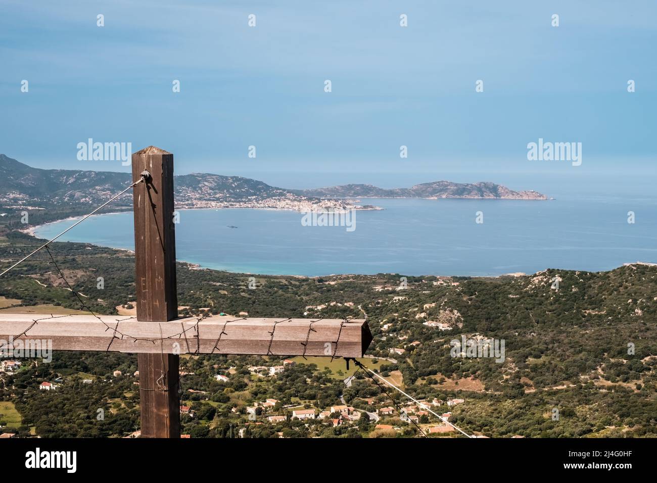View of the bay of Calvi and Revellata from a wooden cross high above the town of Lumio in the Balagne region of Corsica Stock Photo