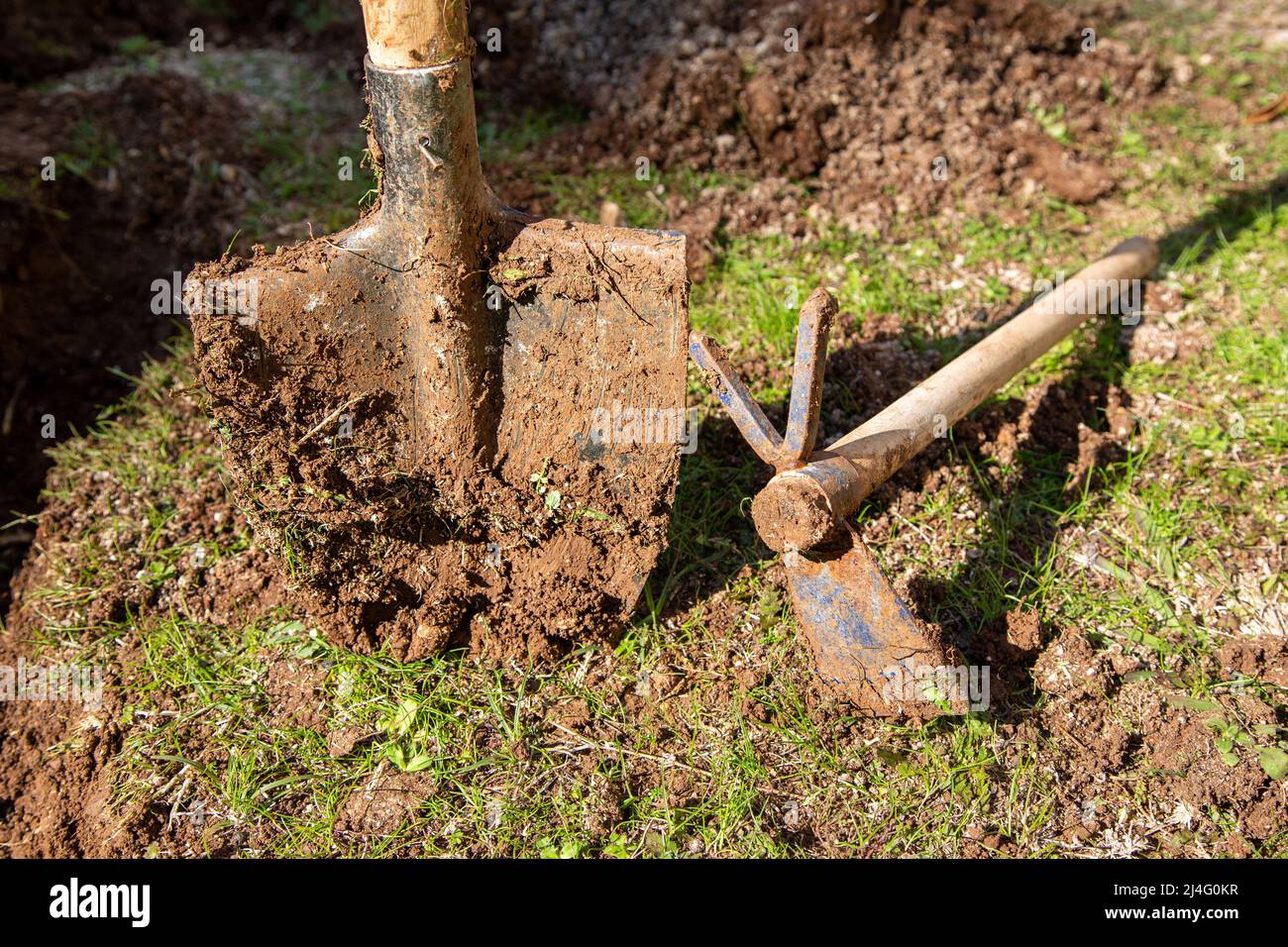 Used garden shovel and hoe with soil in selective focus. Farming shovel