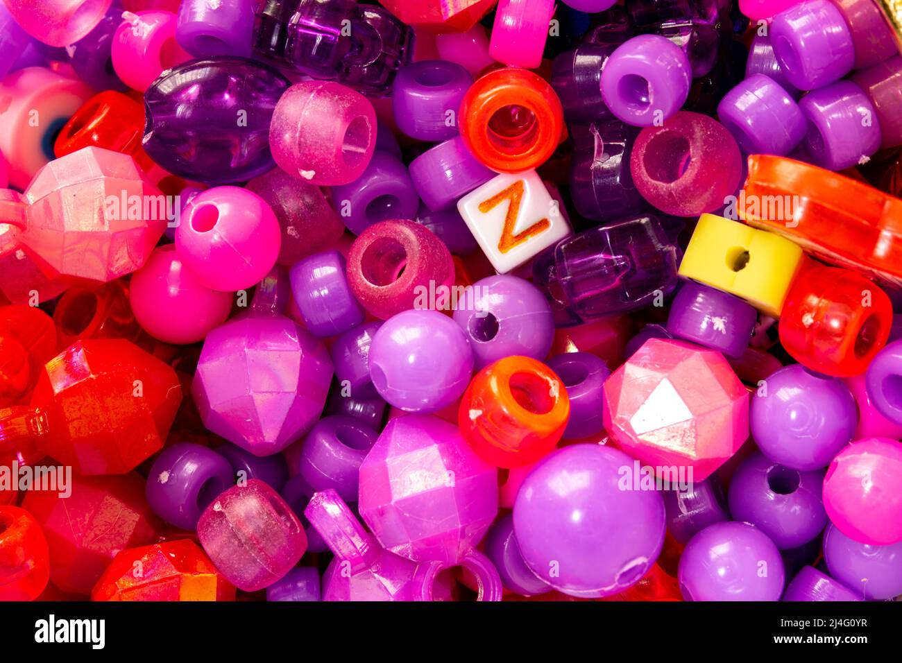 White cube with the letter Z on it among plastic beads of different colors and shapes. Generation Z concept. Stock Photo