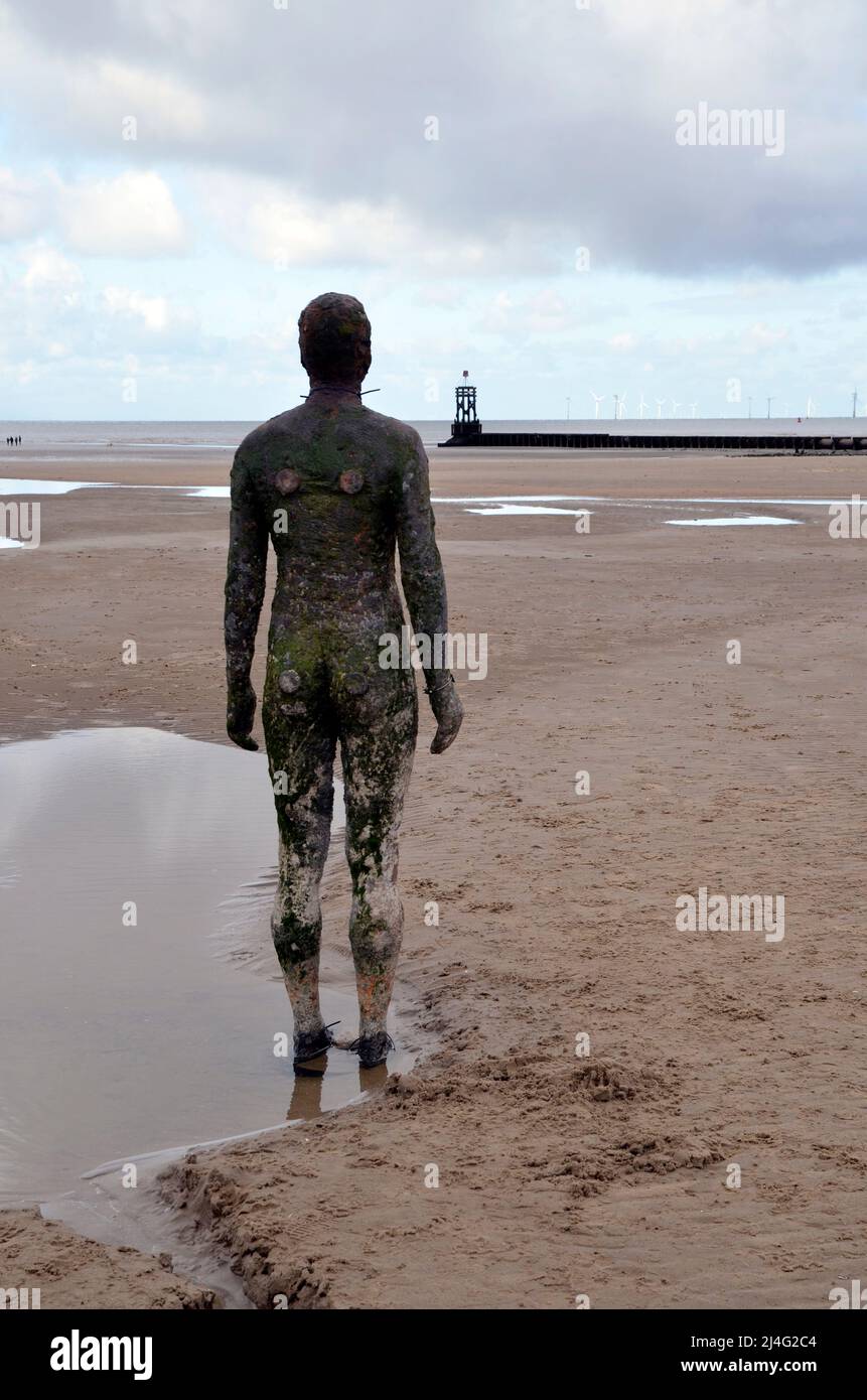 Statues on Crosby Beach in Merseyside, part of the Another Place installation by sculptor and artist Antony Gormley Stock Photo