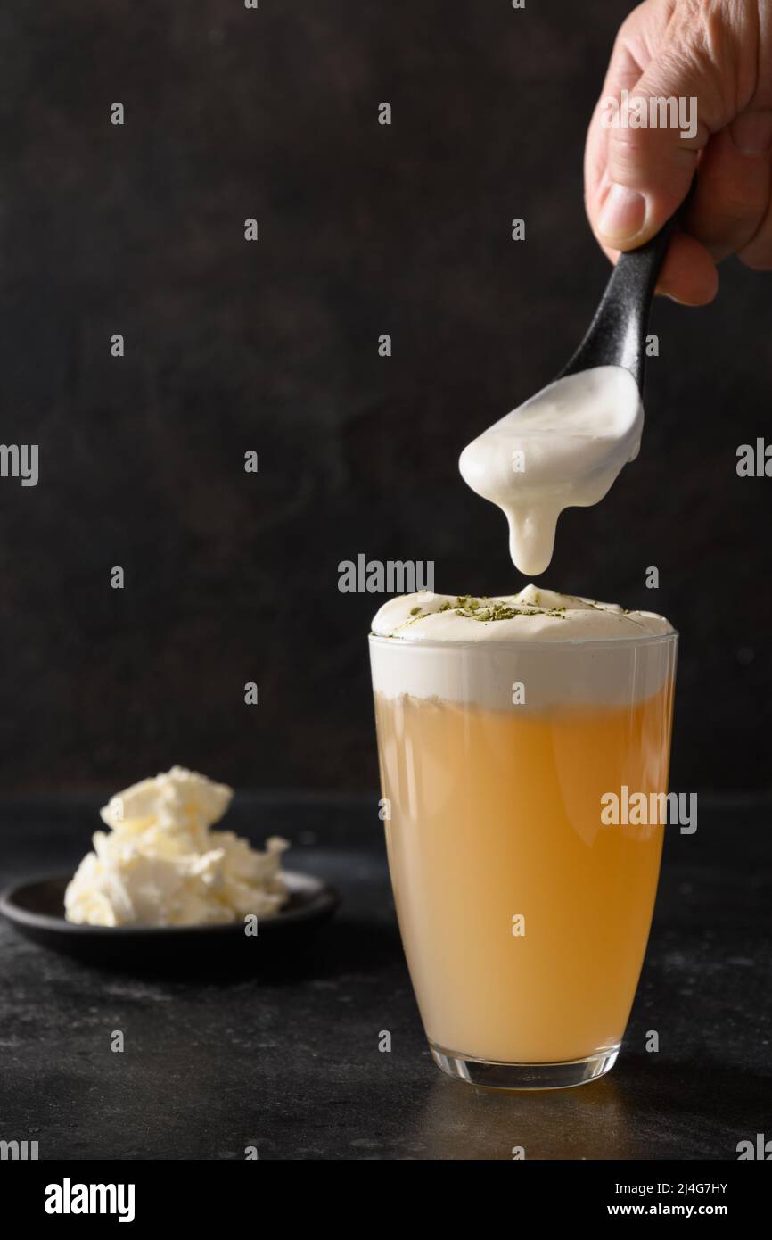 Chinese asian beverage cheese tea in glass with layer of whipped cream