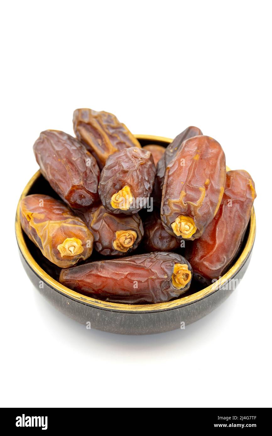 Date fruit isolated on a white background. A bowl of date fruit (Medjoul). close up Stock Photo