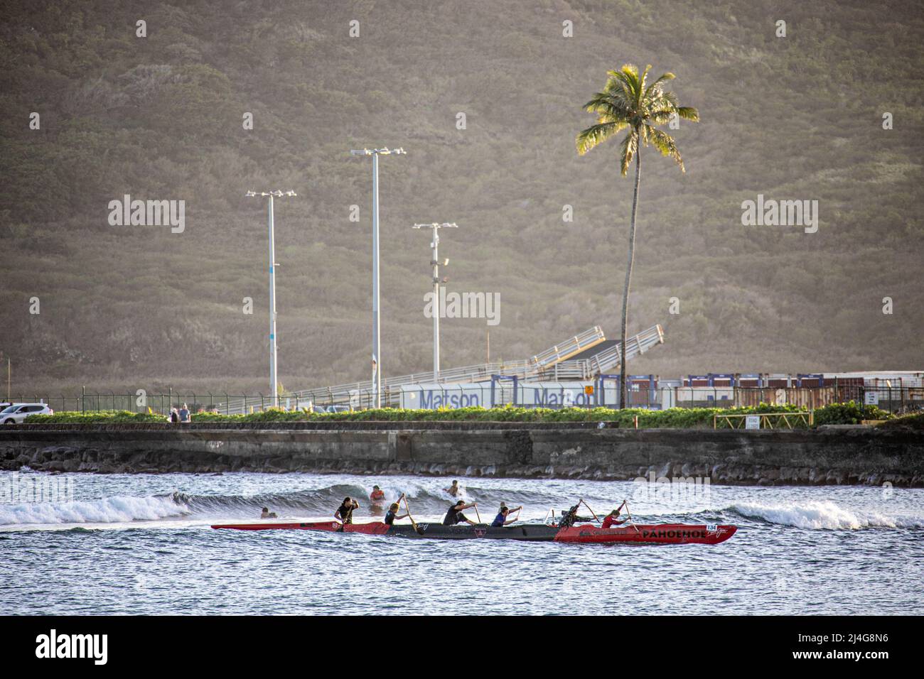 Outrigger canoe riding the waves to Kalapaki Beach in Lihue, Kauai, Hawai Stock Photo