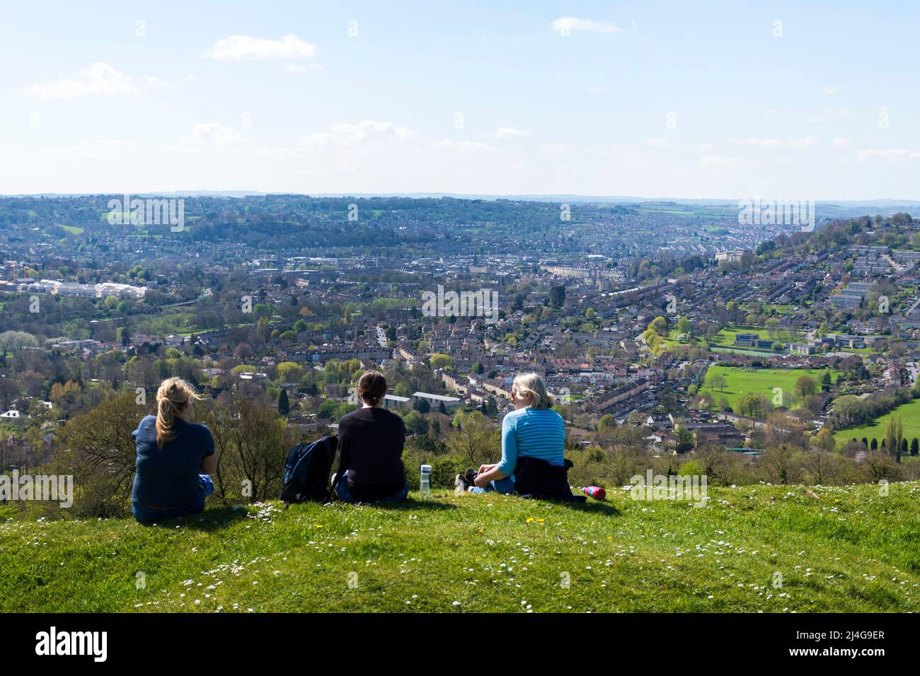 Batheaston, Somerset, UK weather. 15th April 2022. On a fine sunny day people on Little Solsbury Hill admire the view looking towards Bath Spa. The former Iron Age fortress hill was made famous in the Peter Gabriel hit song 'Solsbury Hill'. Stock Photo