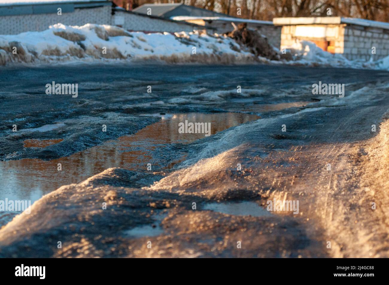 Spring thaw on the road, snow and melting ice Stock Photo