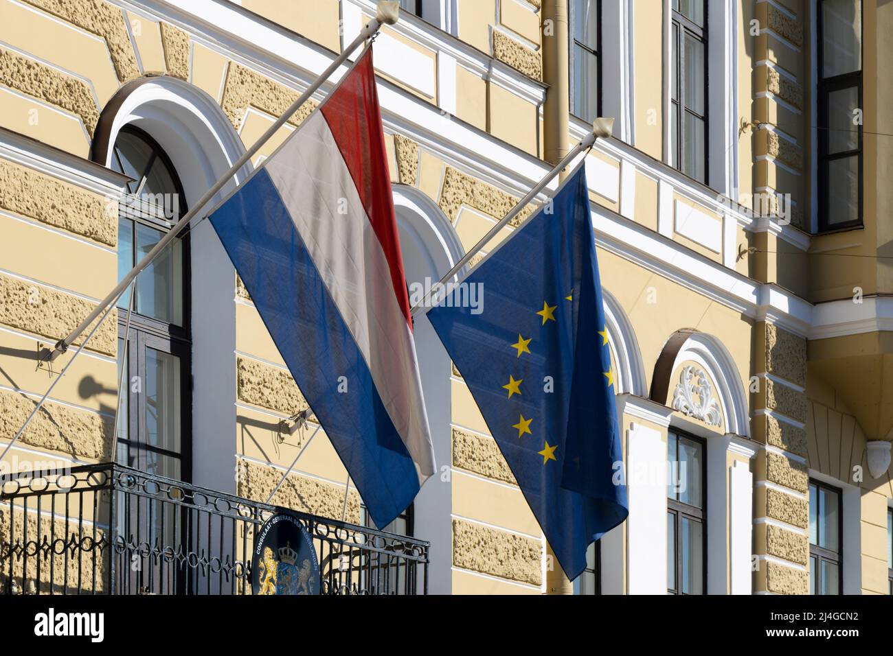 Flags of the European Union and the Netherlands hang on the facade of the embassy building Stock Photo