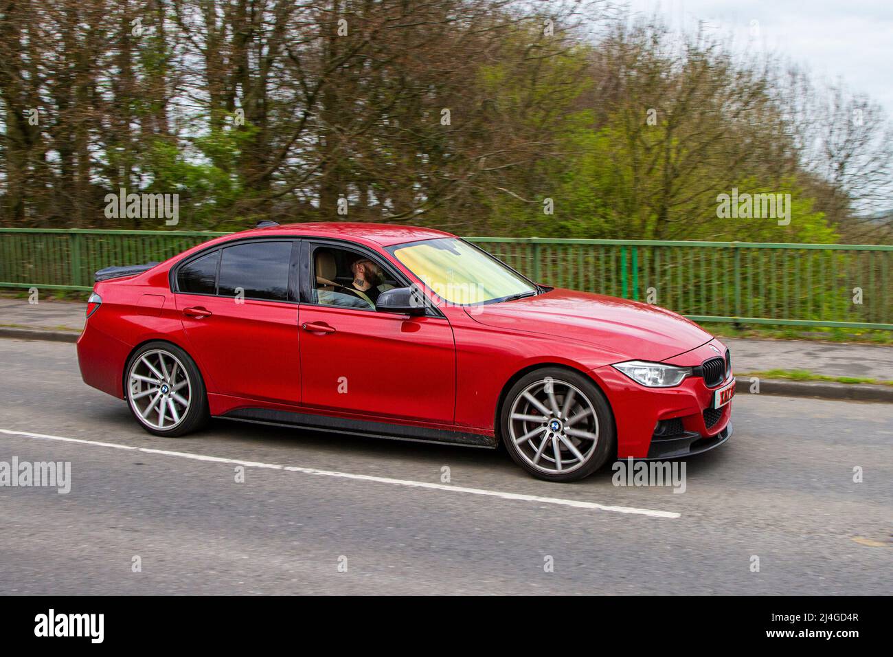 2013 red custom BMW 3 Series 330D M SPORT 2993cc diesel 8 speed automatic, crossing motorway bridge near Manchester, UK Stock Photo