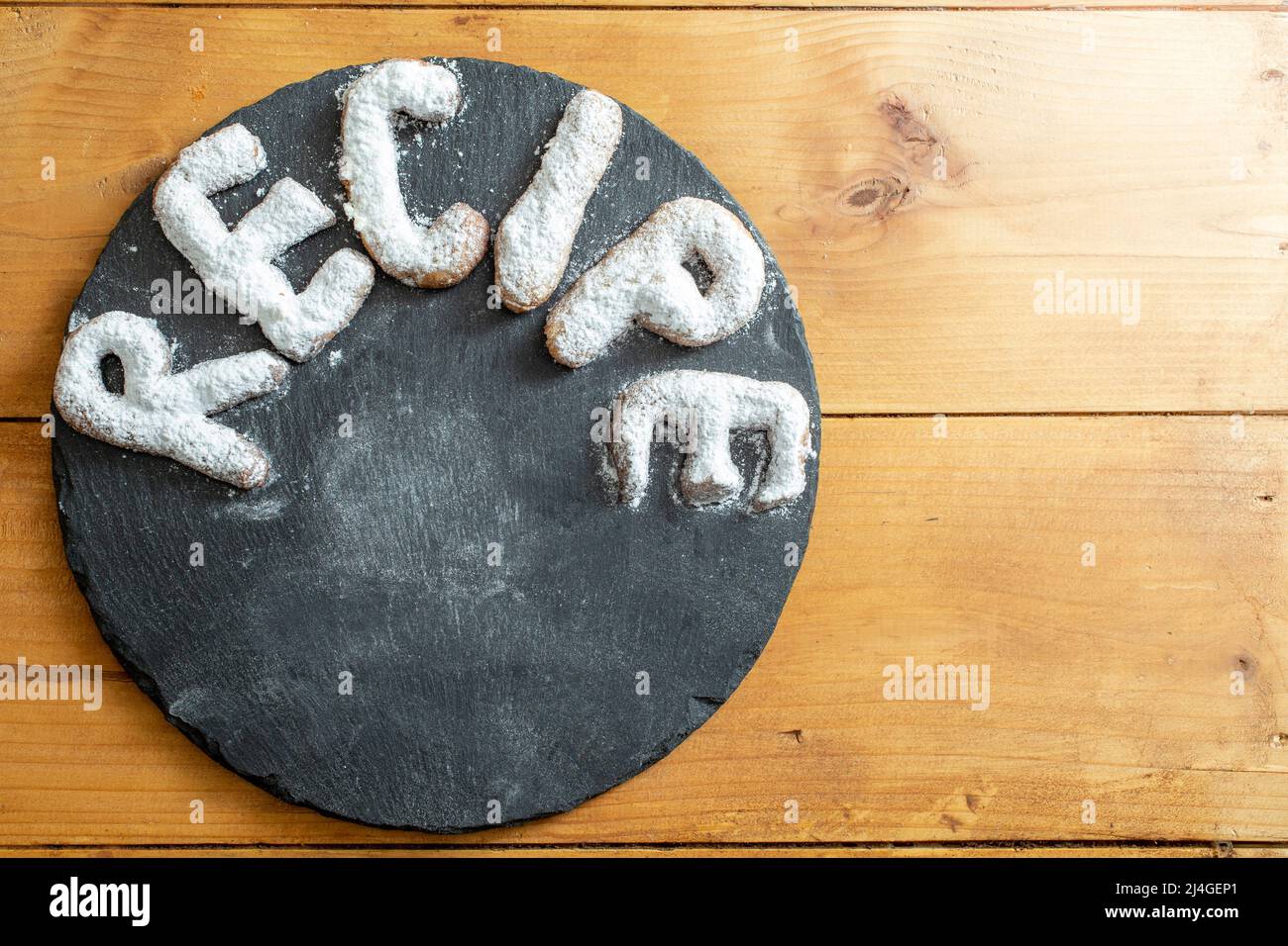 Recipe written with cookie letters on a black stone slab Stock Photo