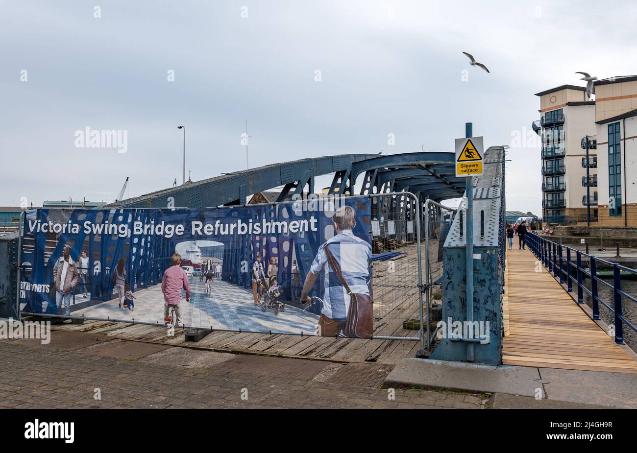 People walking on walkway of old Victoria swing bridge under restoration, Water of Leith, Edinburgh, Scotland, UK Stock Photo