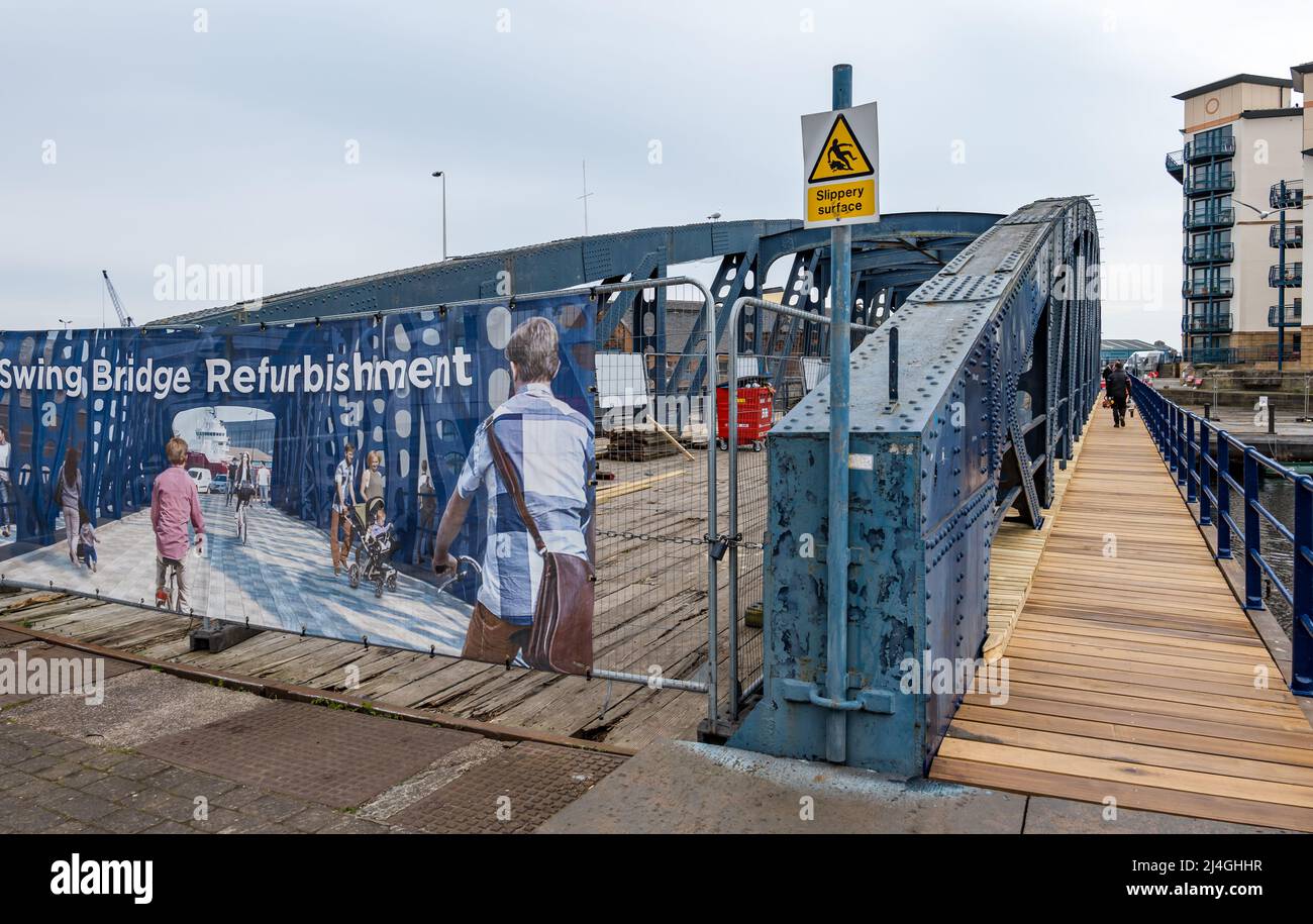 People walking on walkway of old Victoria swing bridge under restoration, Water of Leith, Edinburgh, Scotland, UK Stock Photo