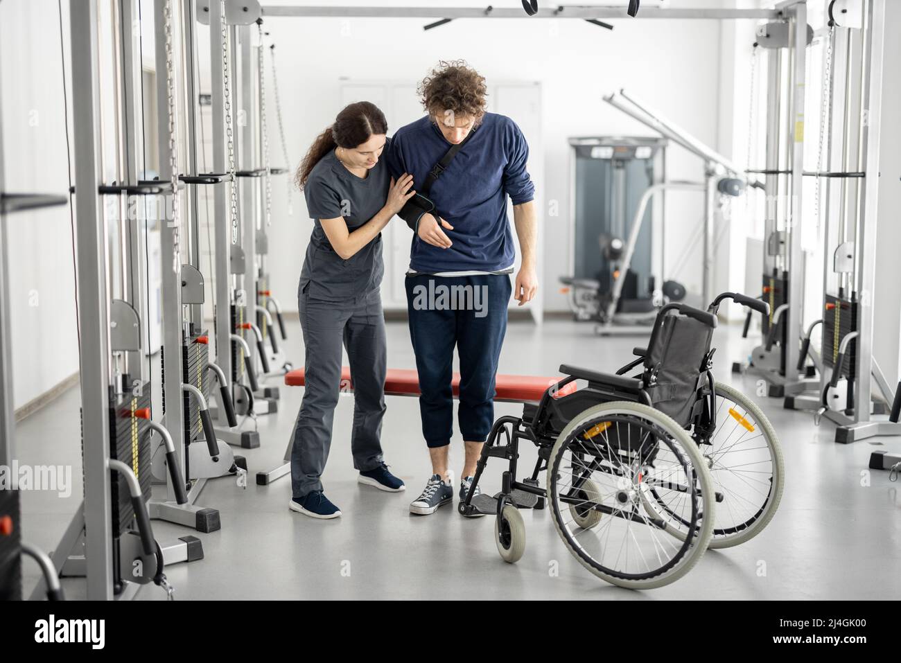 Rehabilitation specialist helps a guy stand out of a wheelchair Stock Photo Alamy