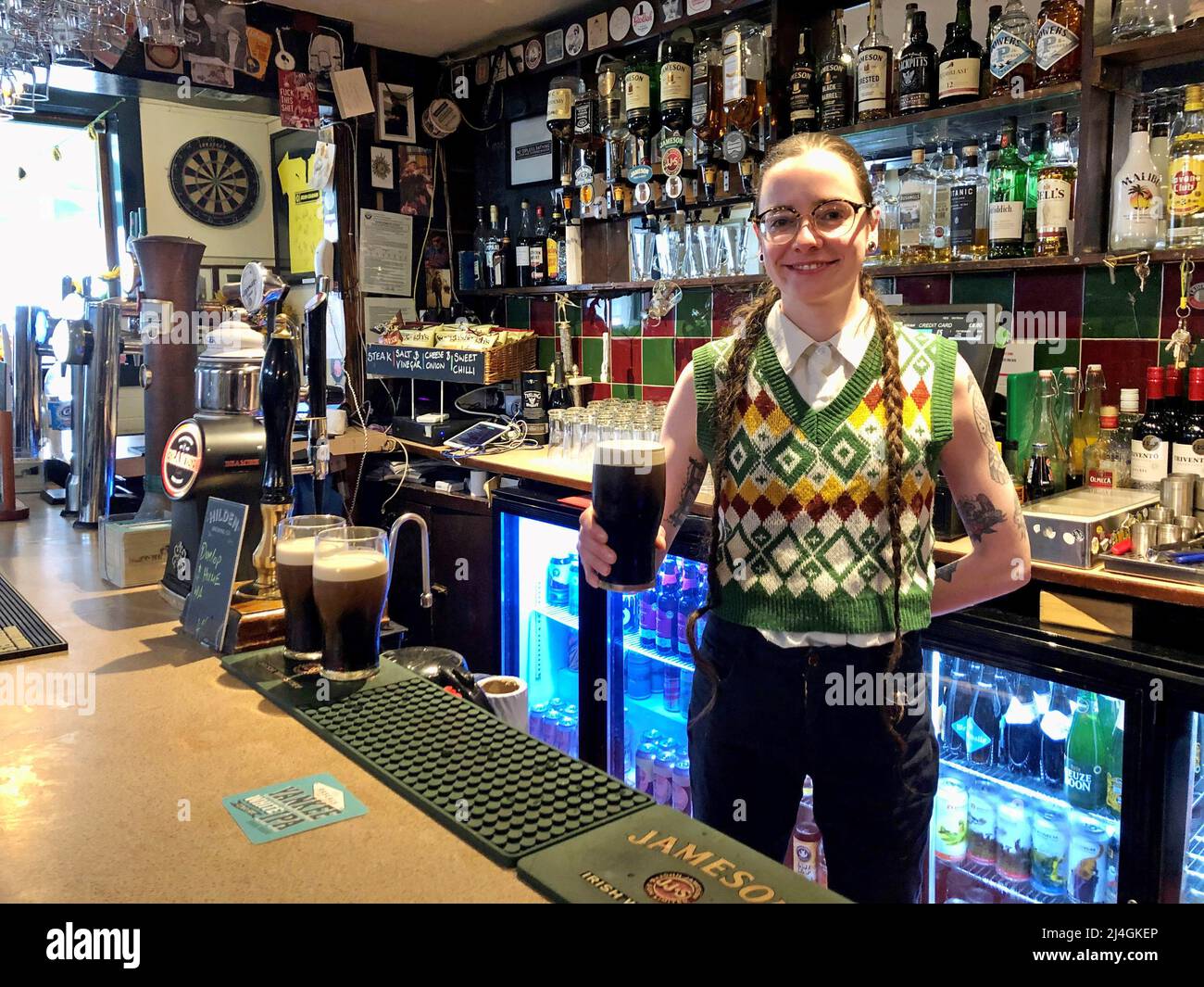 Suzi Magee serves a pint at the Sunflower pub in Belfast, as pubs can