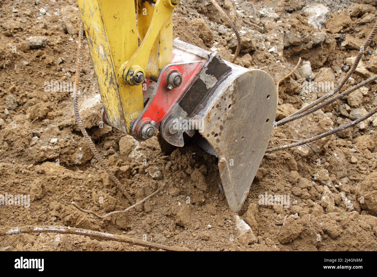 The gripper of an excavator digs into a clay soil Stock Photo